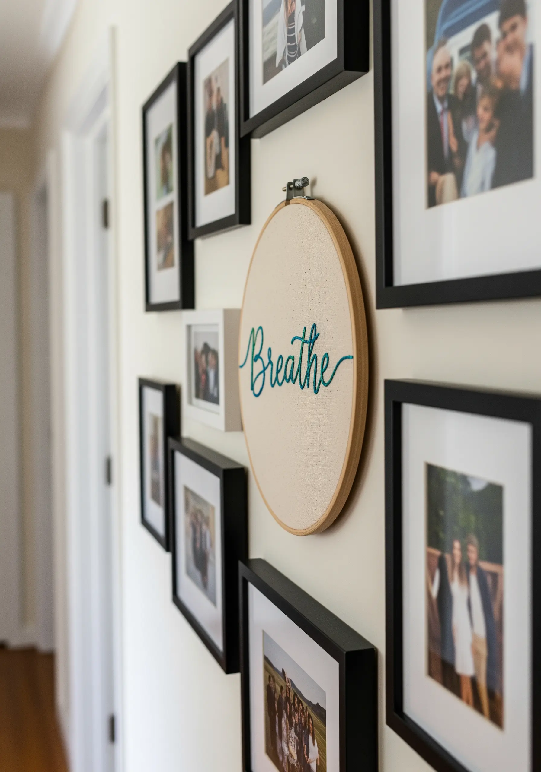Embroidery hoop with the word 'Breathe' in a blue-green gradient script on a gallery wall.