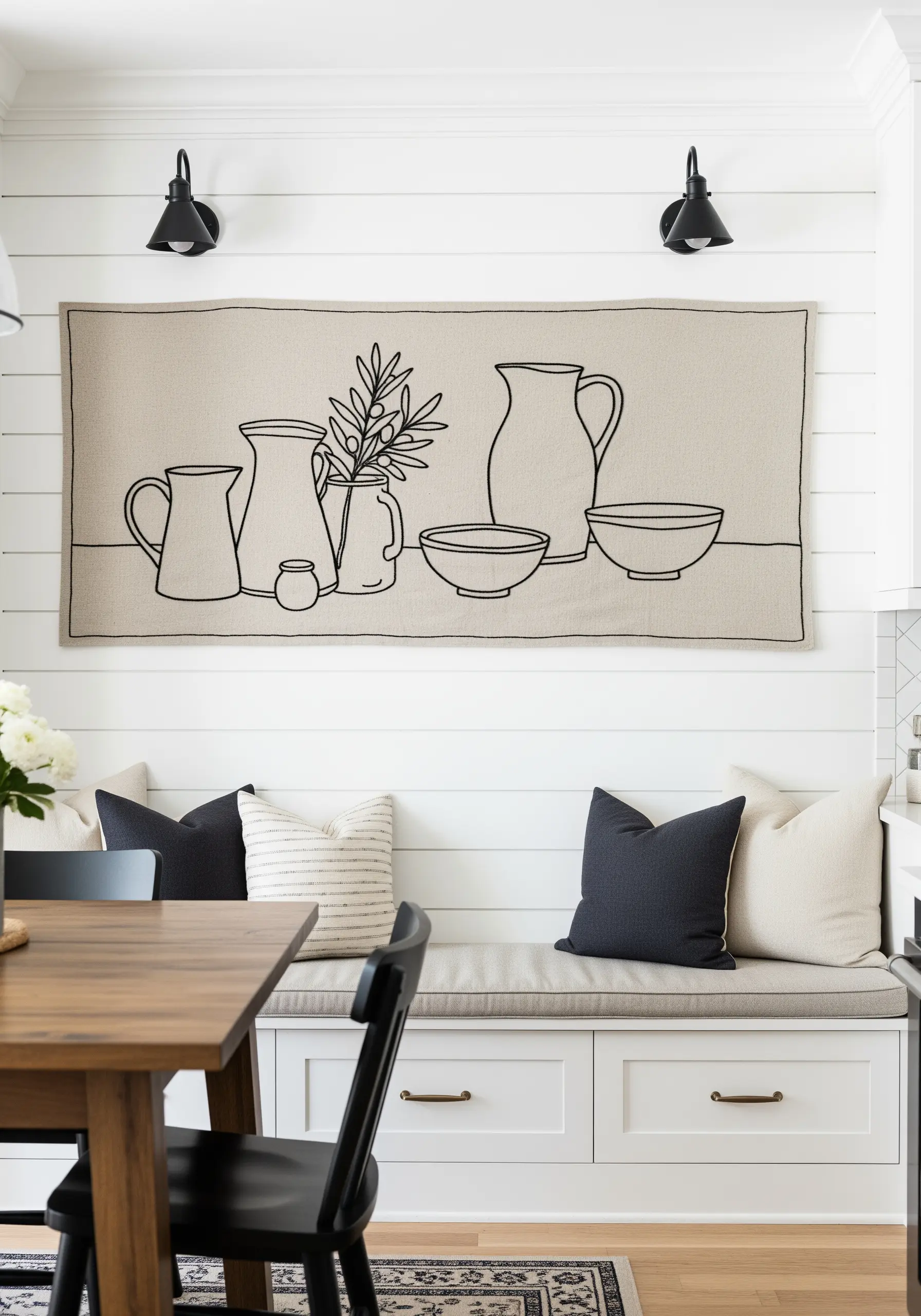 Long, horizontal line art embroidery of still life pitchers and bowls on neutral linen.