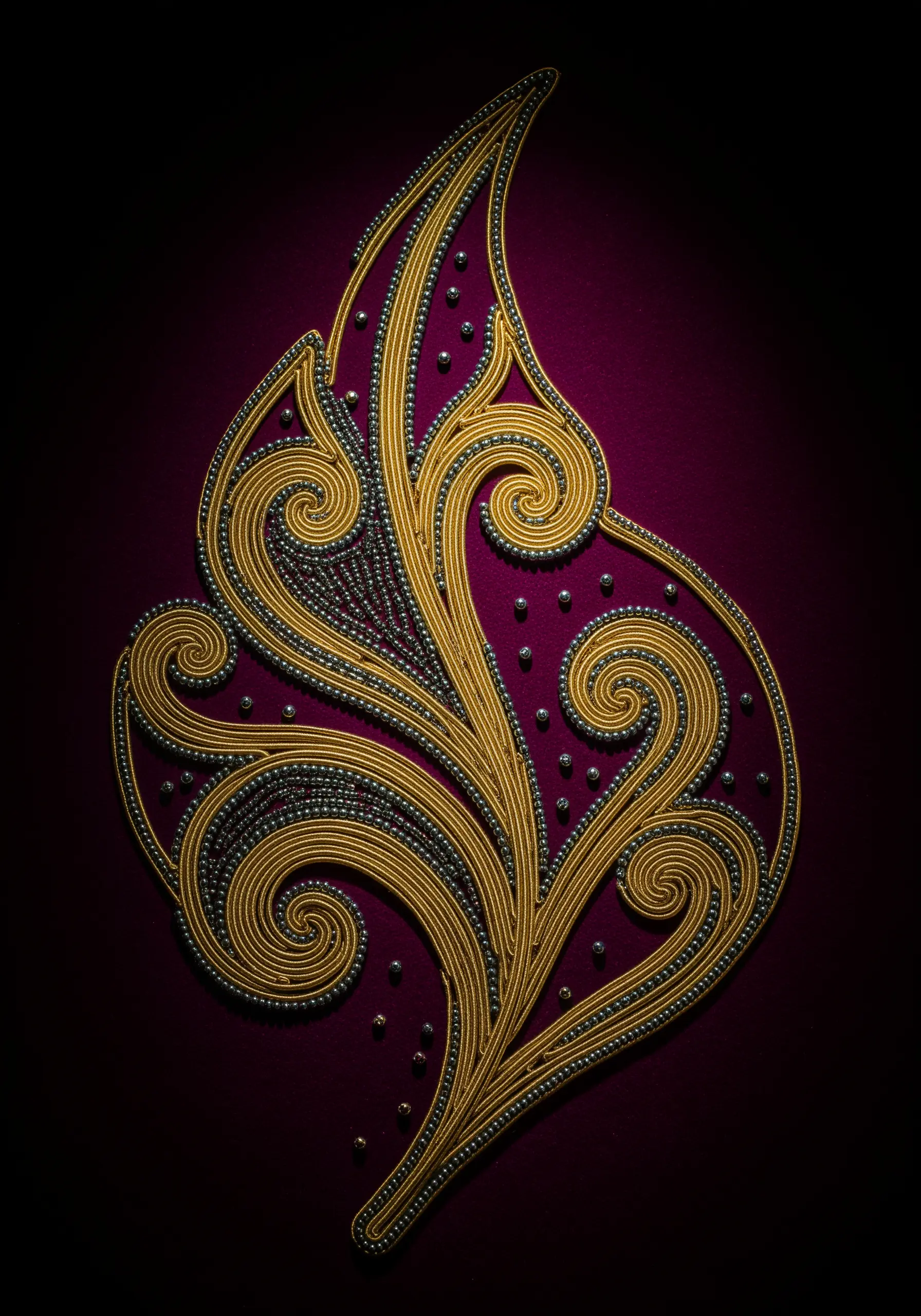 Goldwork leaf with couched metallic cord and seed bead outlines for veins.