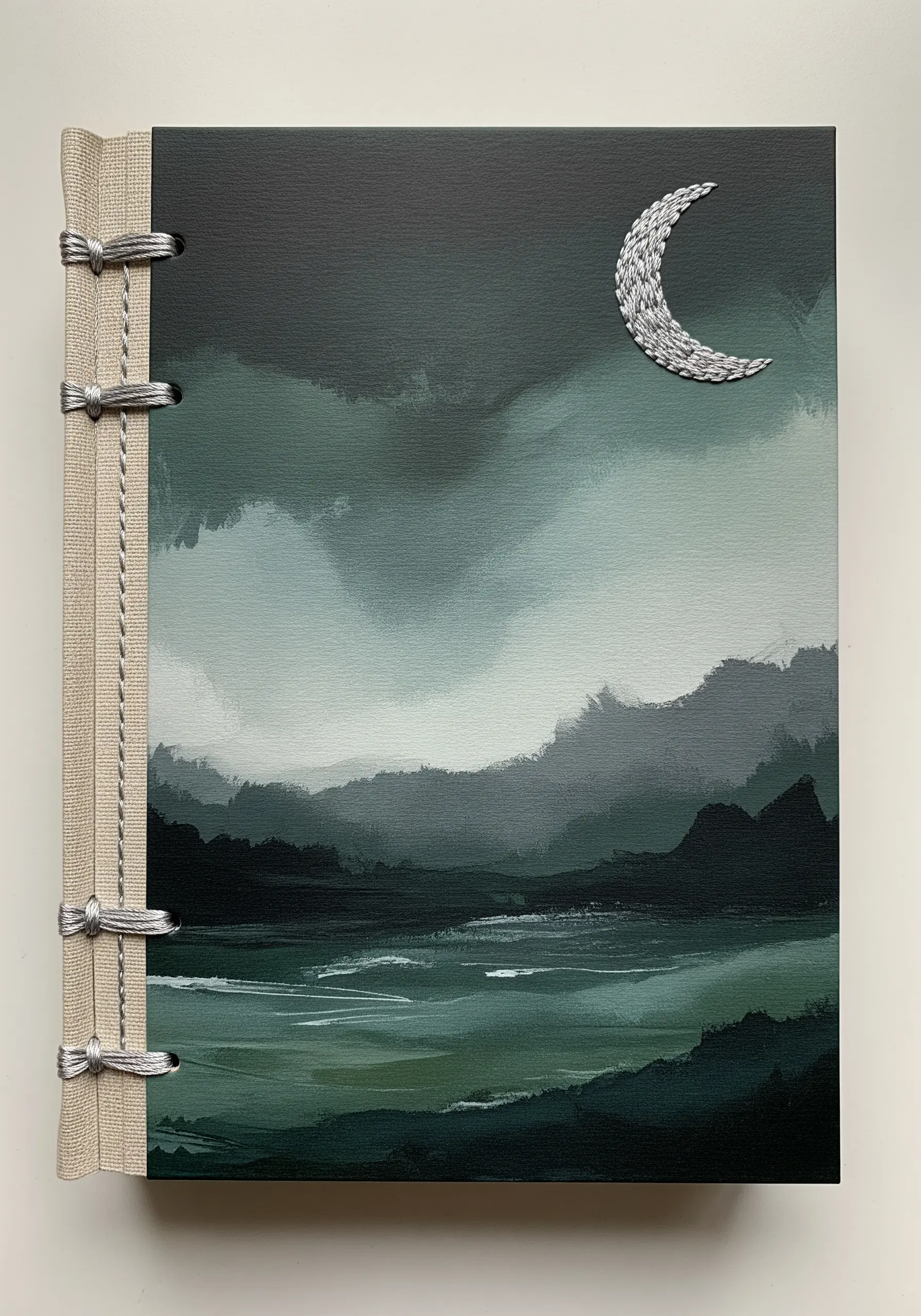 A painted book cover of a dark landscape with a silver embroidered moon.