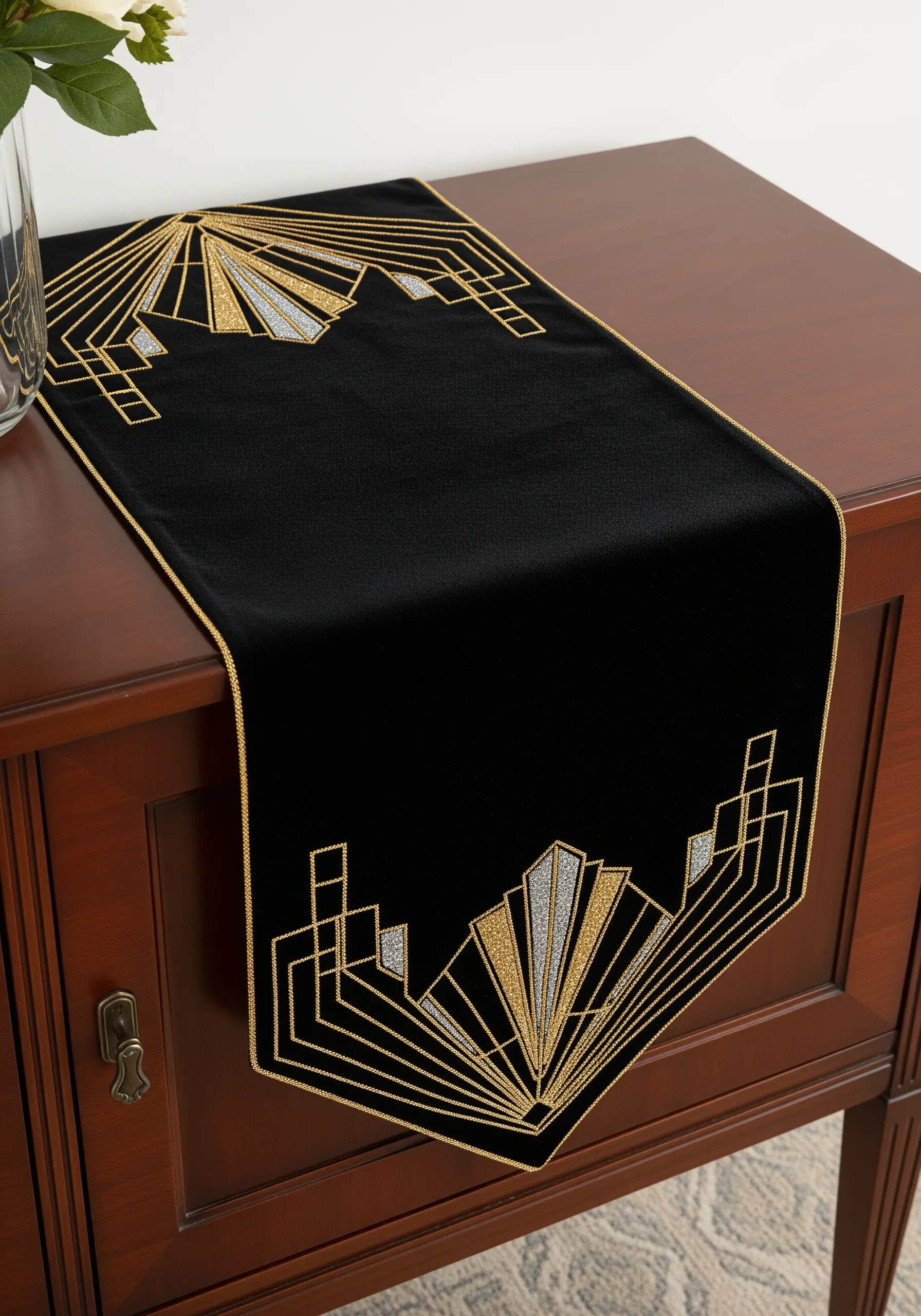 Art Deco sunburst design in gold and silver metallic thread on a black table runner.