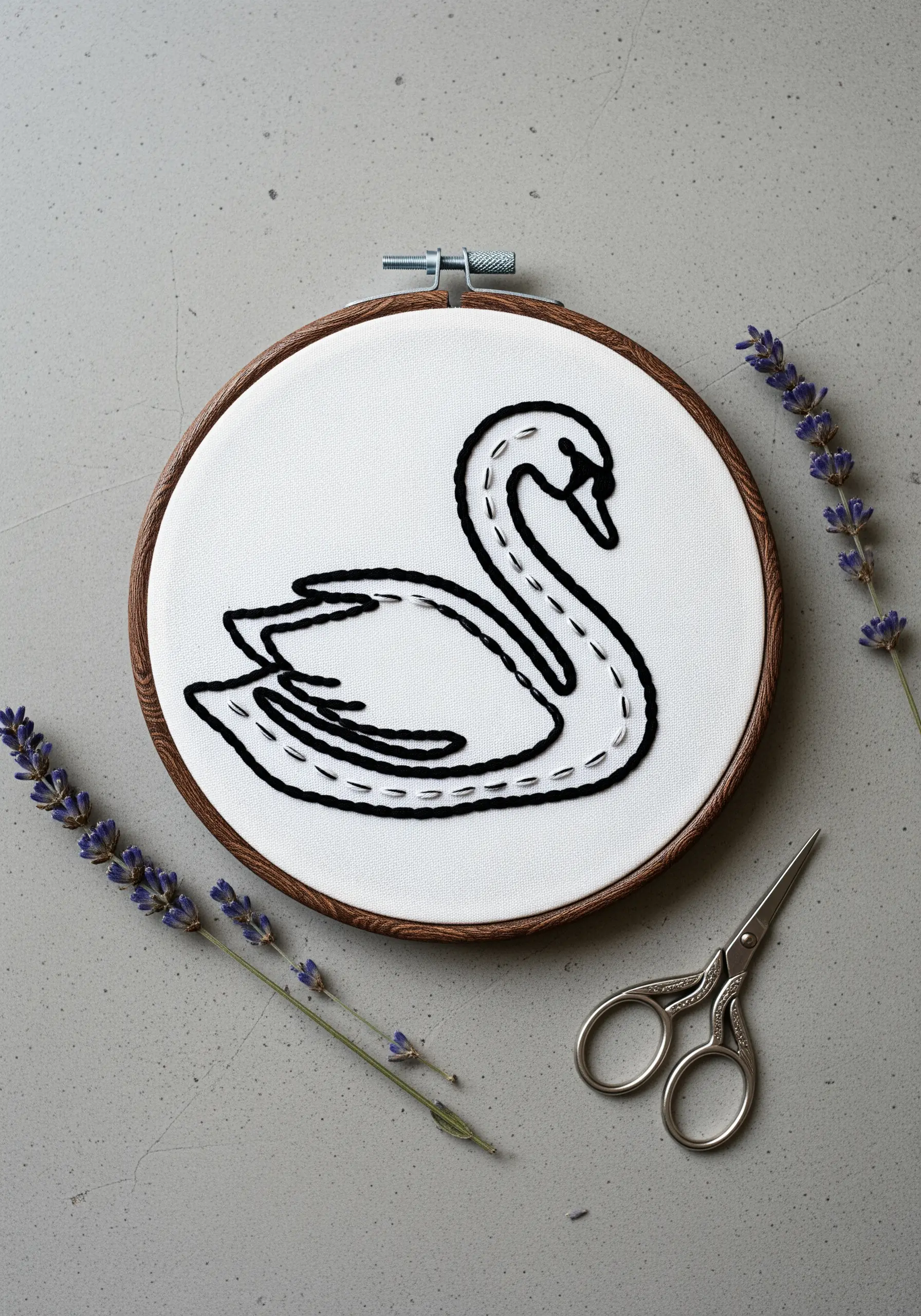 Black thread embroidery of a swan with dashed running stitch outlines.
