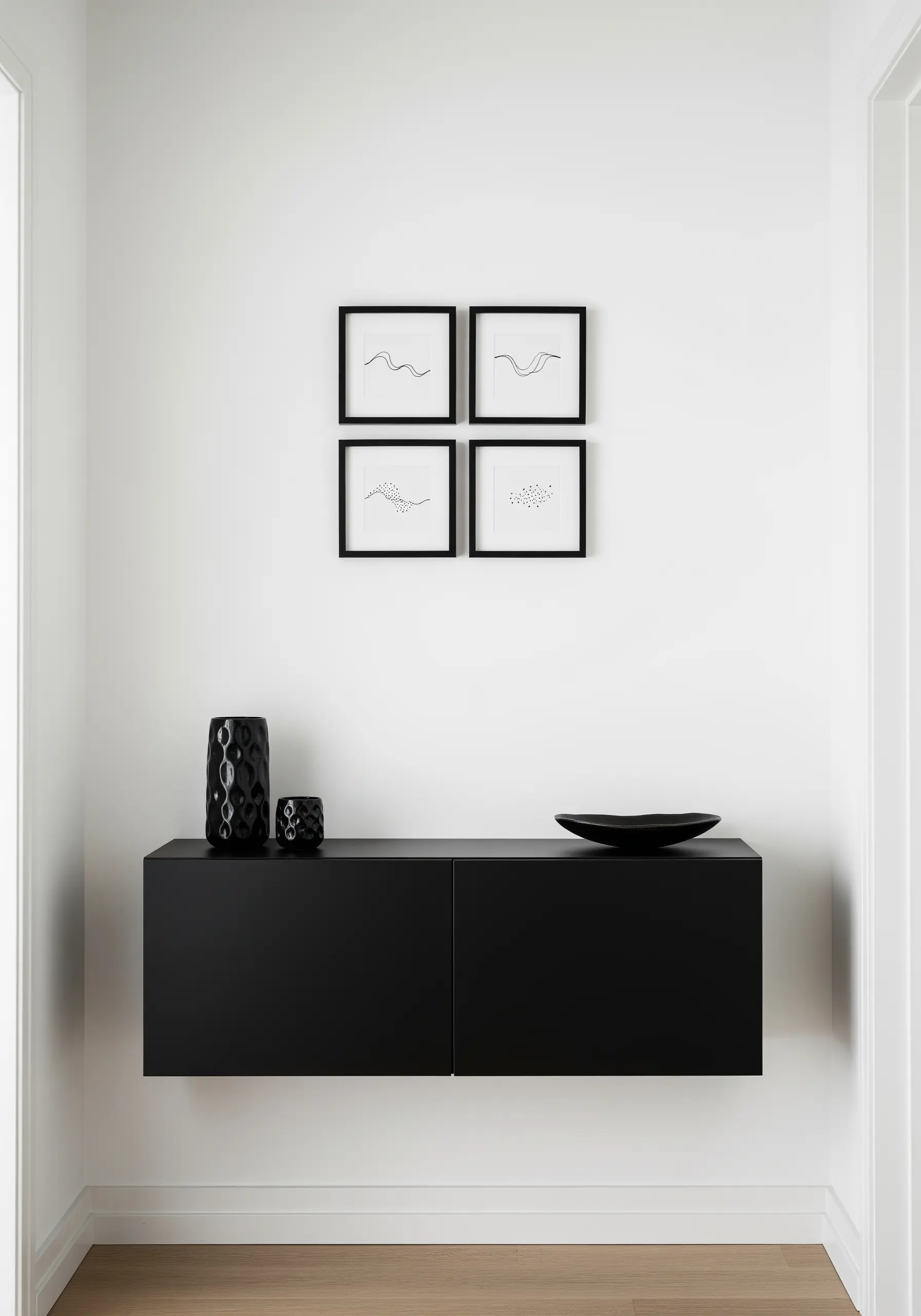Four small framed artworks, each with a single black thread embroidered in a simple wave-like line.
