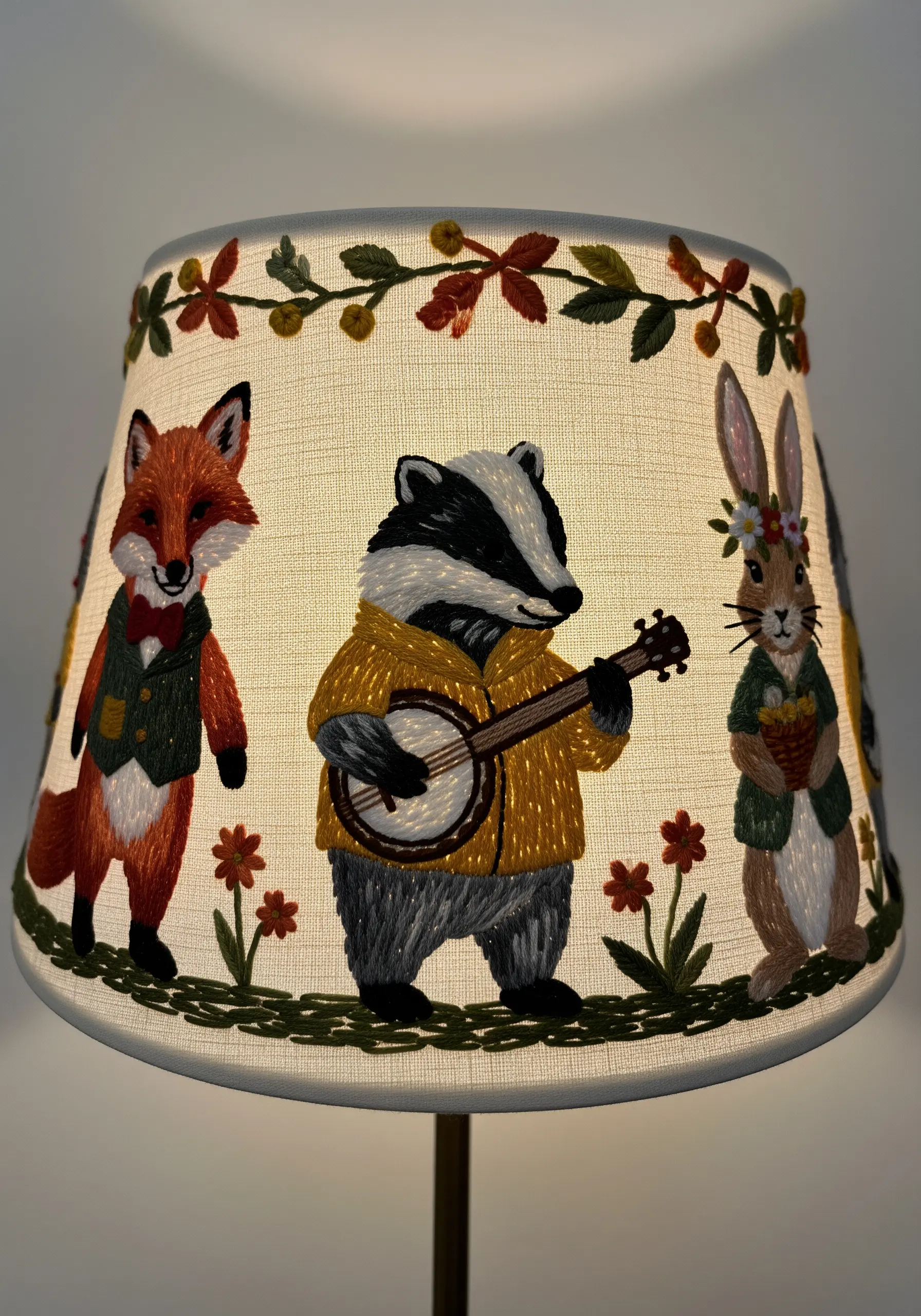 An embroidered lampshade featuring whimsical animals like a fox, badger, and rabbit playing music.