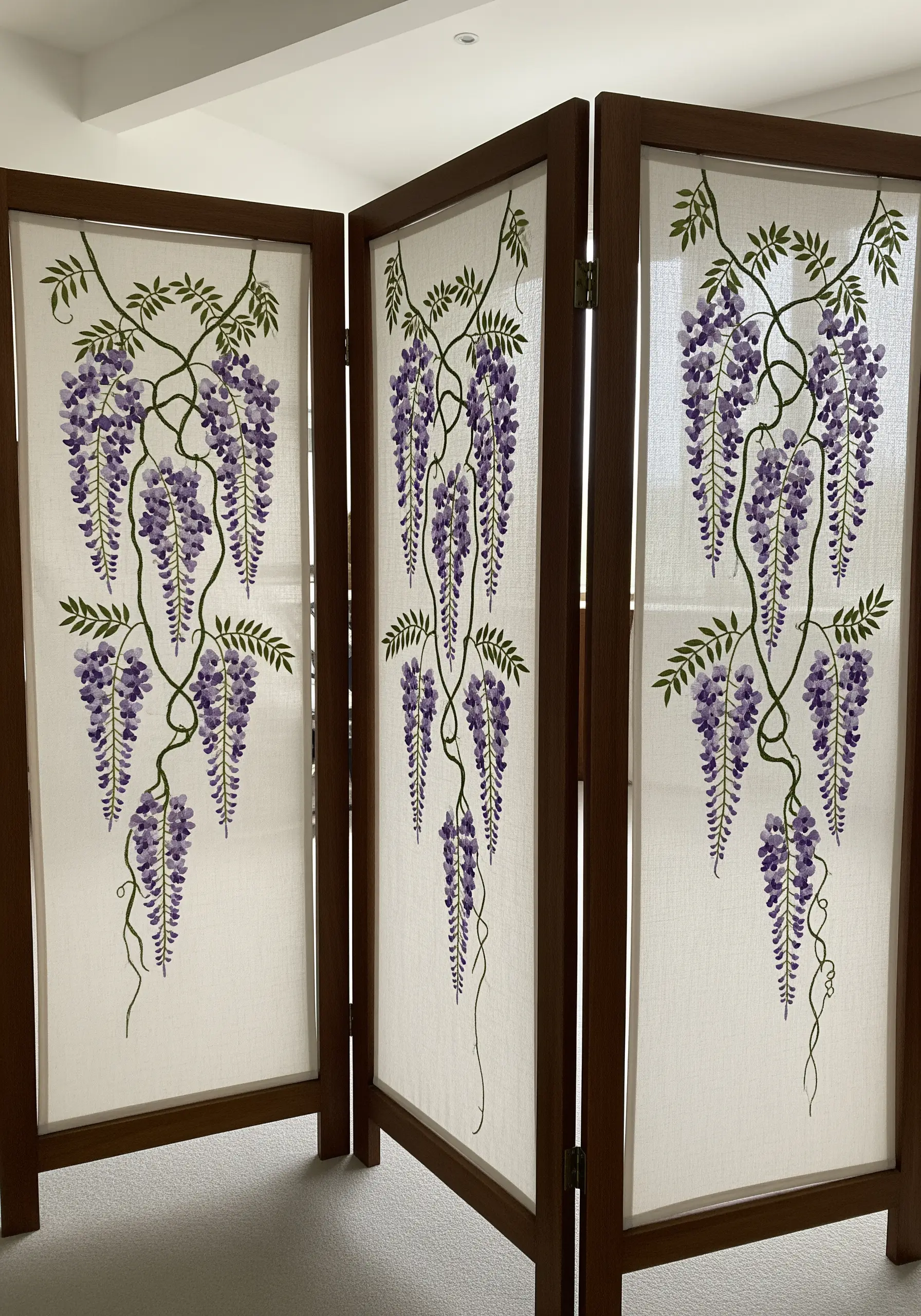 A three-panel wooden room divider with sheer fabric embroidered with wisteria vines.