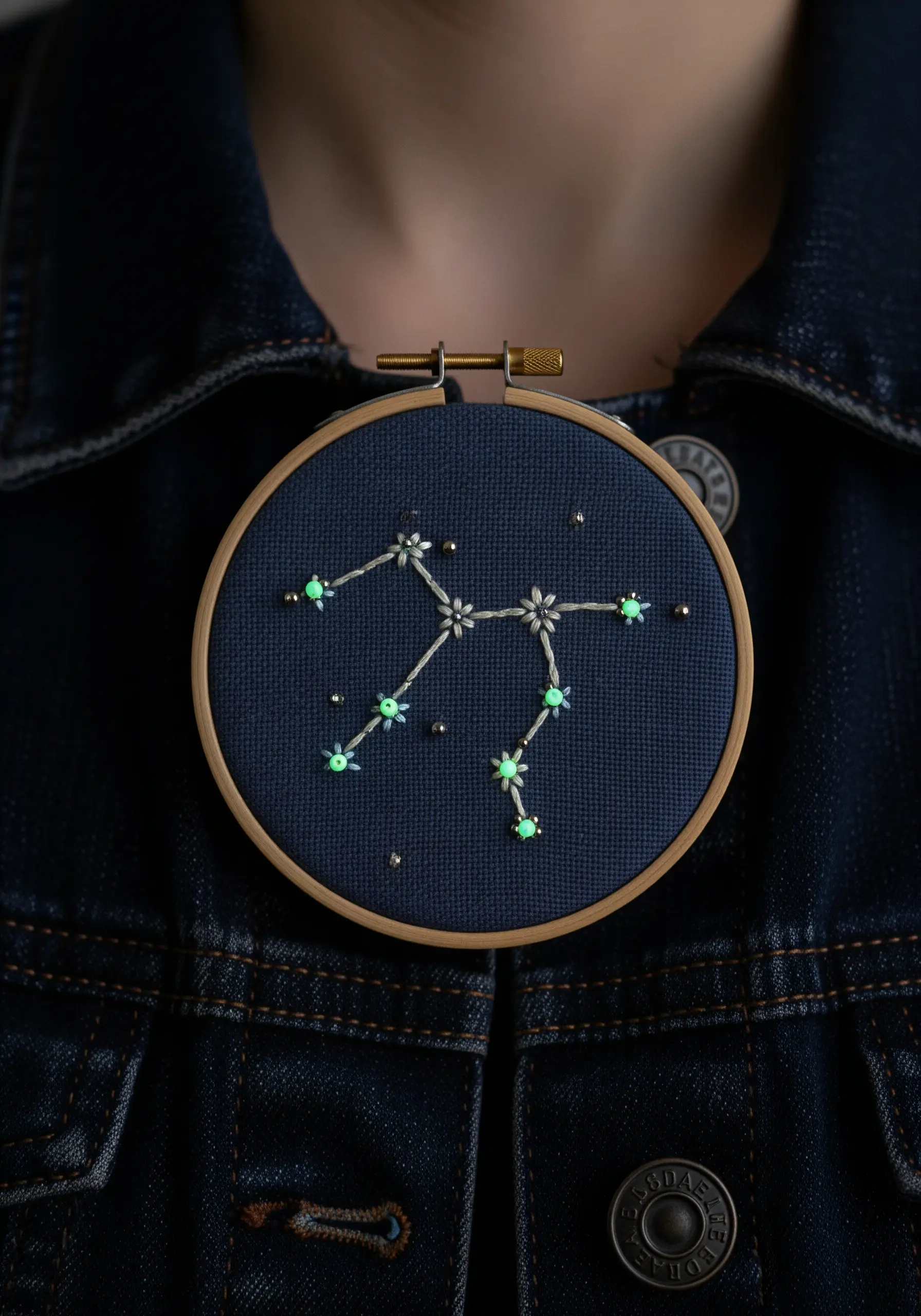 A zodiac constellation embroidered with glow-in-the-dark thread and silver beads.