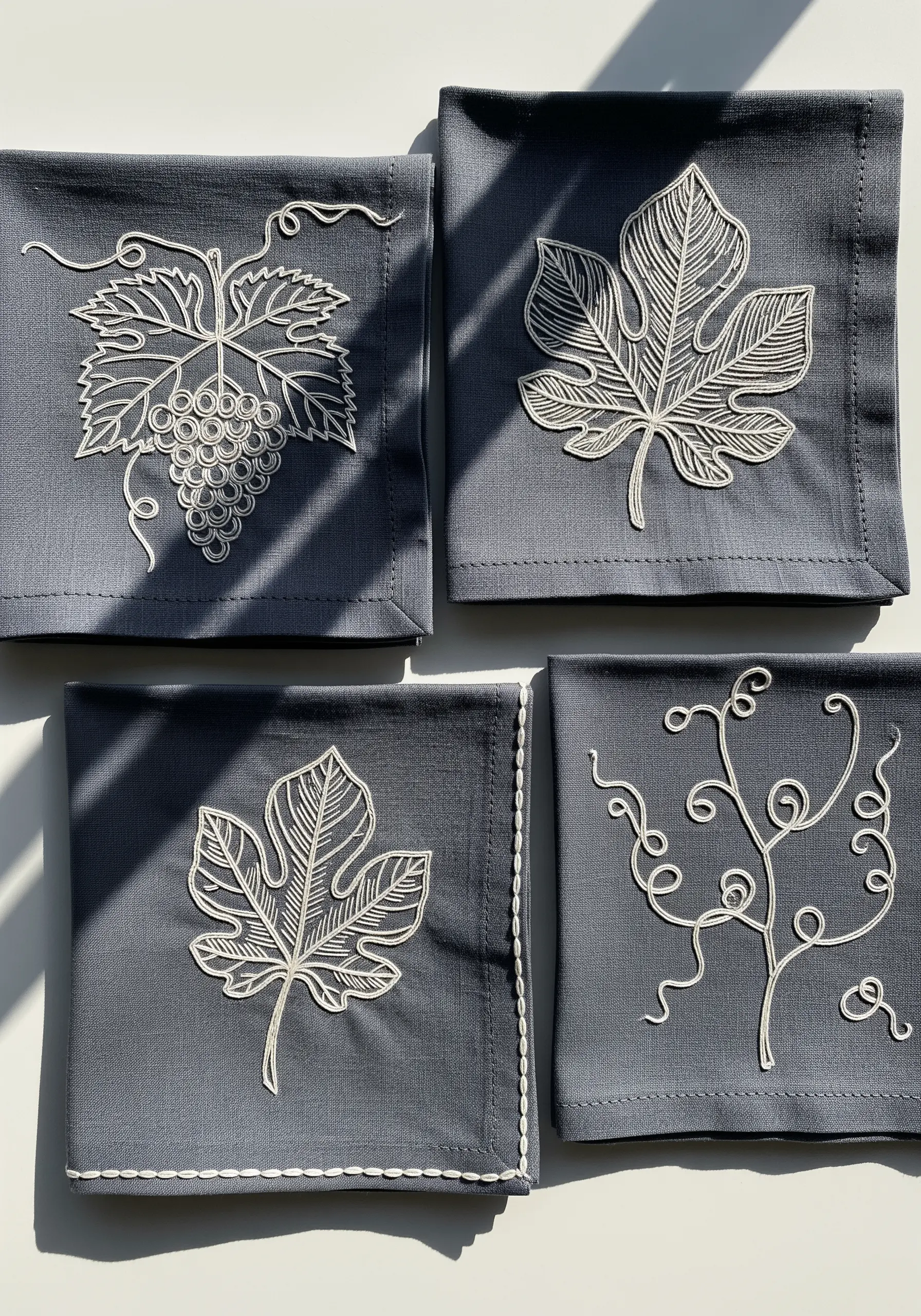 White thread leaf outlines embroidered on dark grey linen napkins
