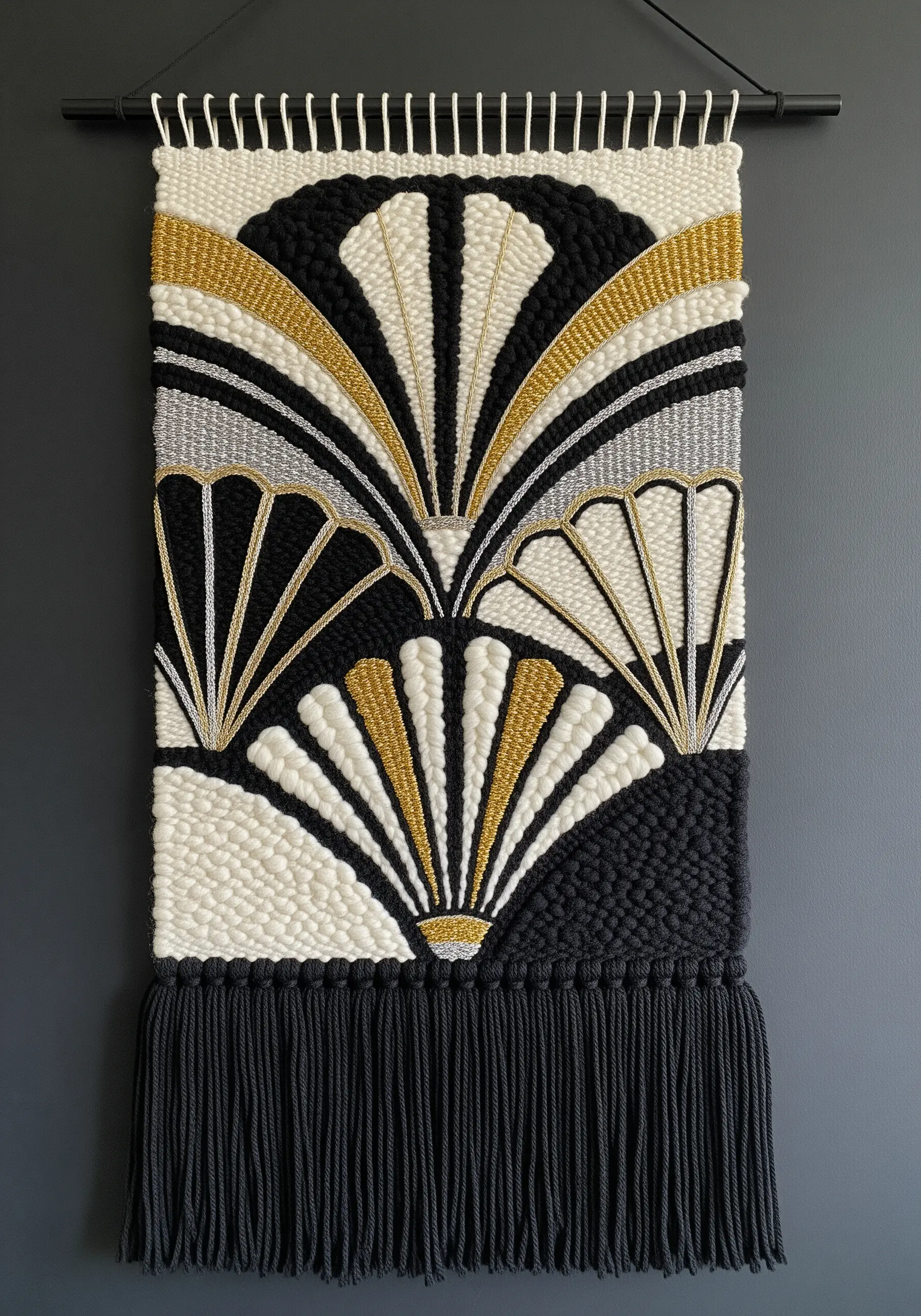 An Art Deco-style woven wall hanging with fan motifs in black, white, gold, and silver.