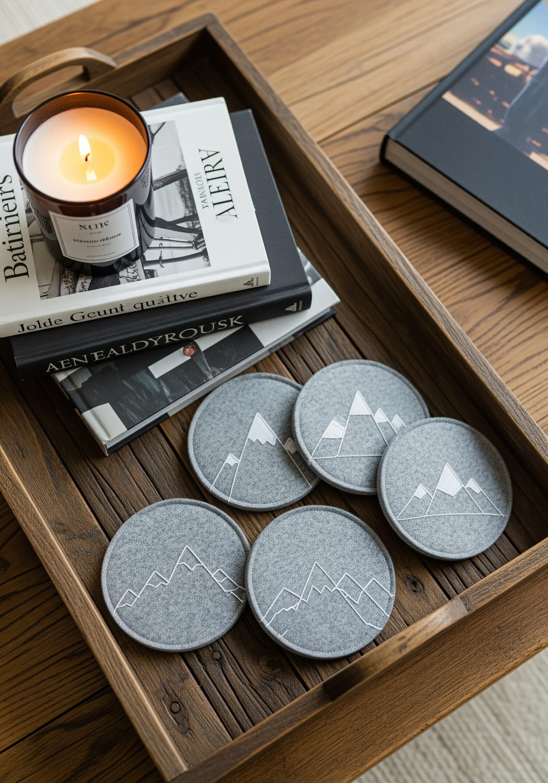 Grey felt coasters with minimalist mountain range outlines stitched in white thread.