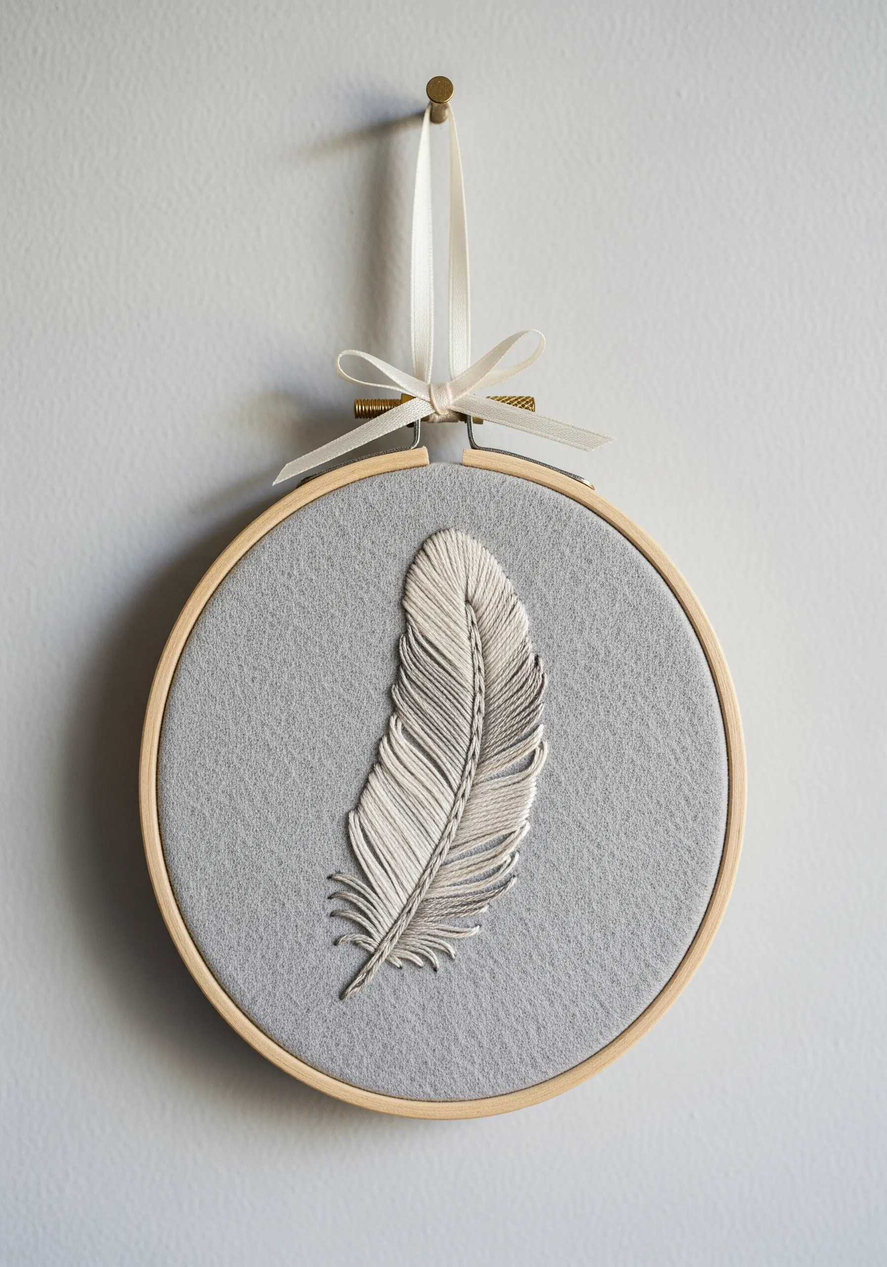 Delicate white and grey feather embroidered with split stitch and straight stitches.