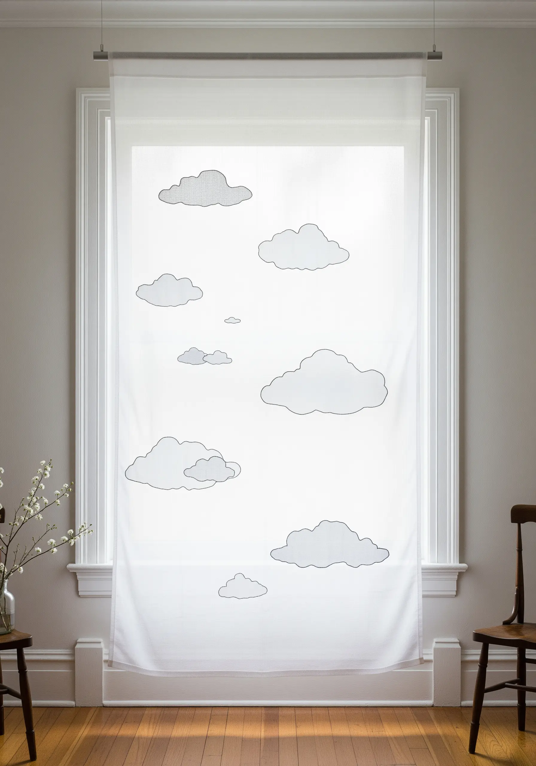 A sheer white window curtain with delicately embroidered cloud outlines.