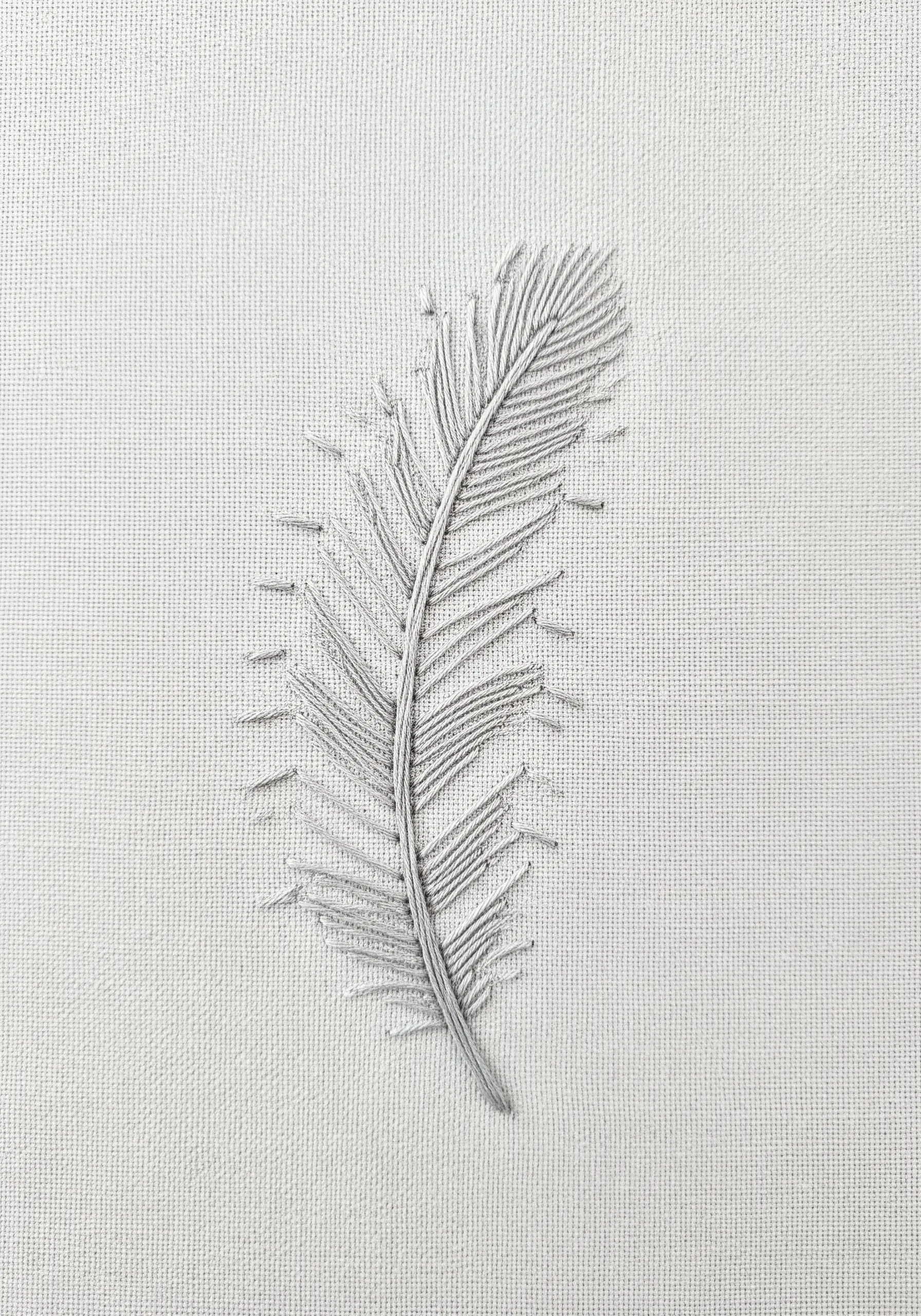 A single feather stitched in light grey thread using an open fishbone stitch.