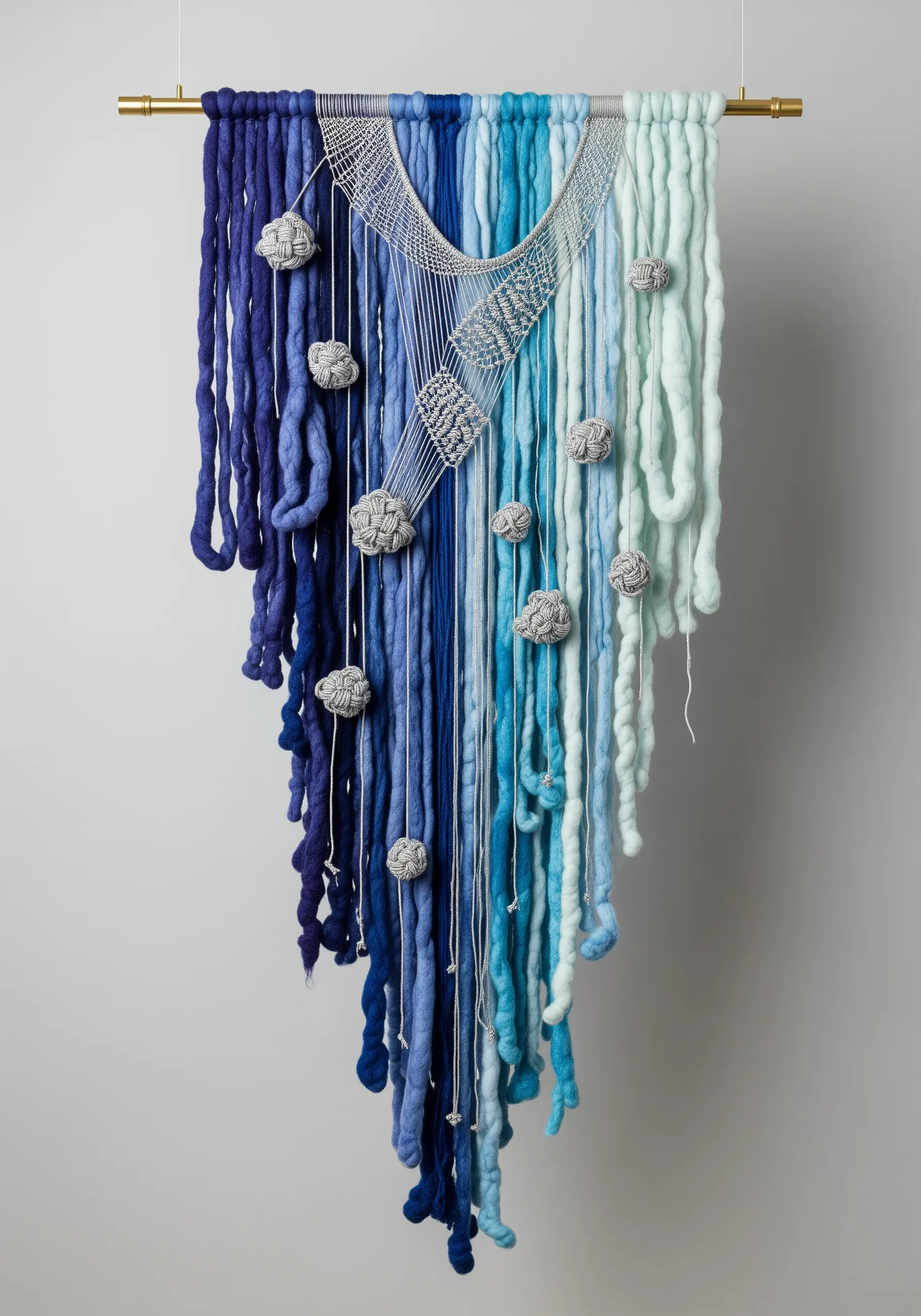 Monochromatic blue yarn wall hanging with a gradient effect and small grey felted details.