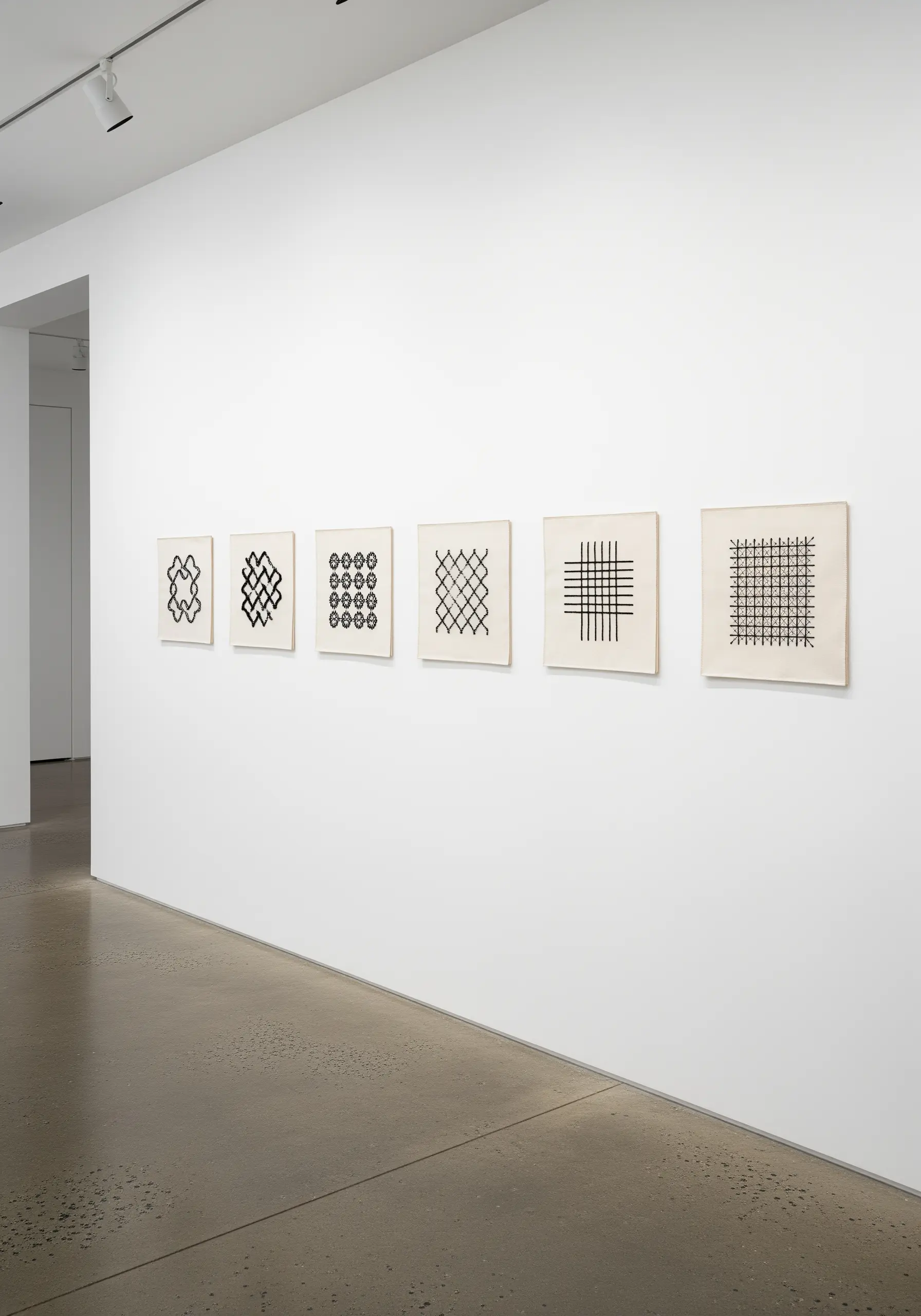 A series of six small, square artworks with different black-and-white geometric grid patterns.
