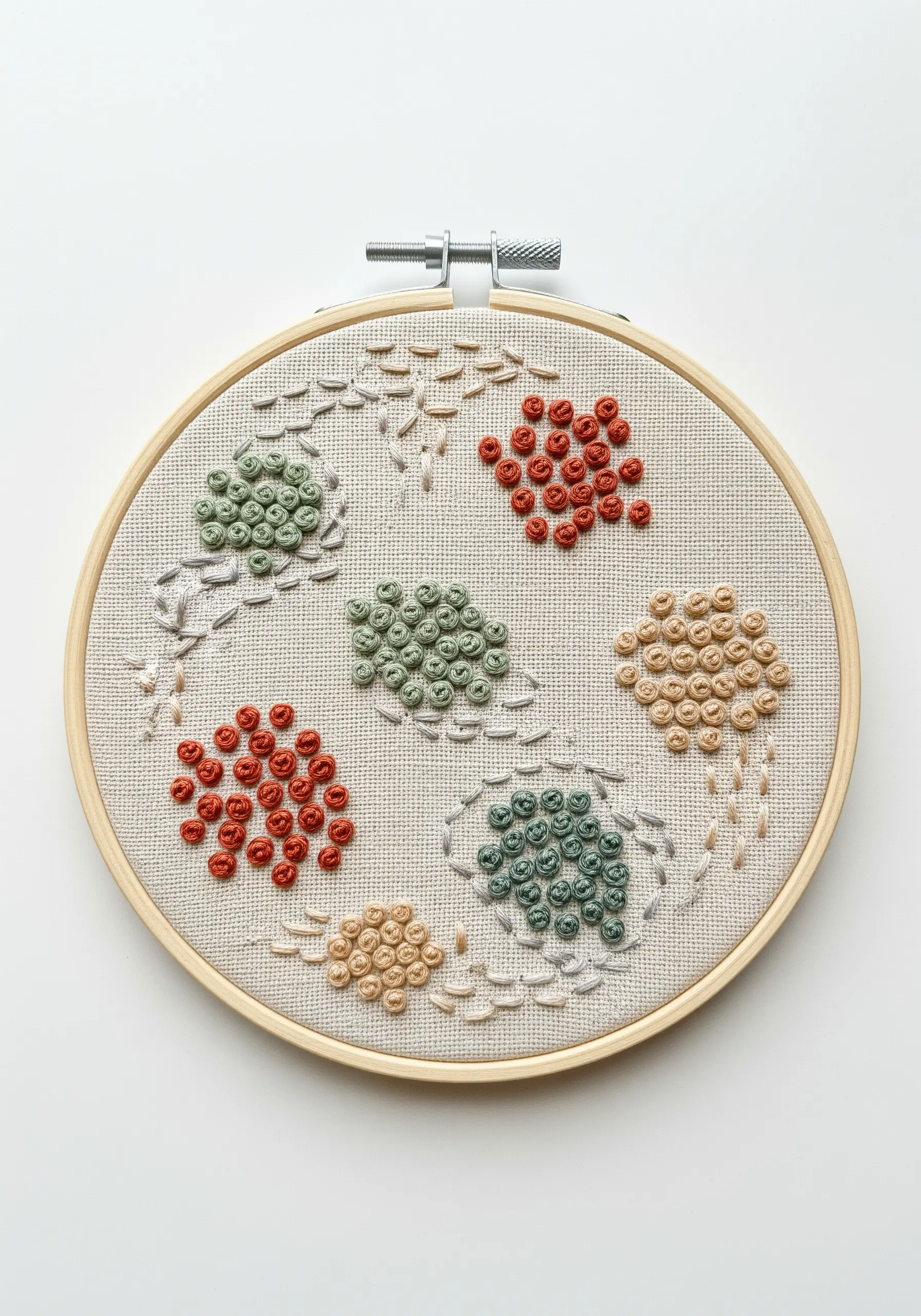 Abstract embroidery hoop with colorful clusters of French knots in organic shapes.
