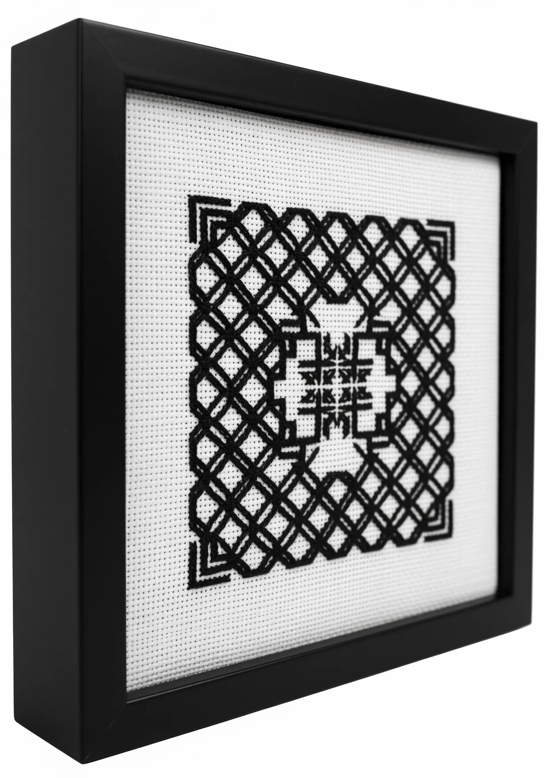 Framed blackwork embroidery with a complex geometric, maze-like pattern.
