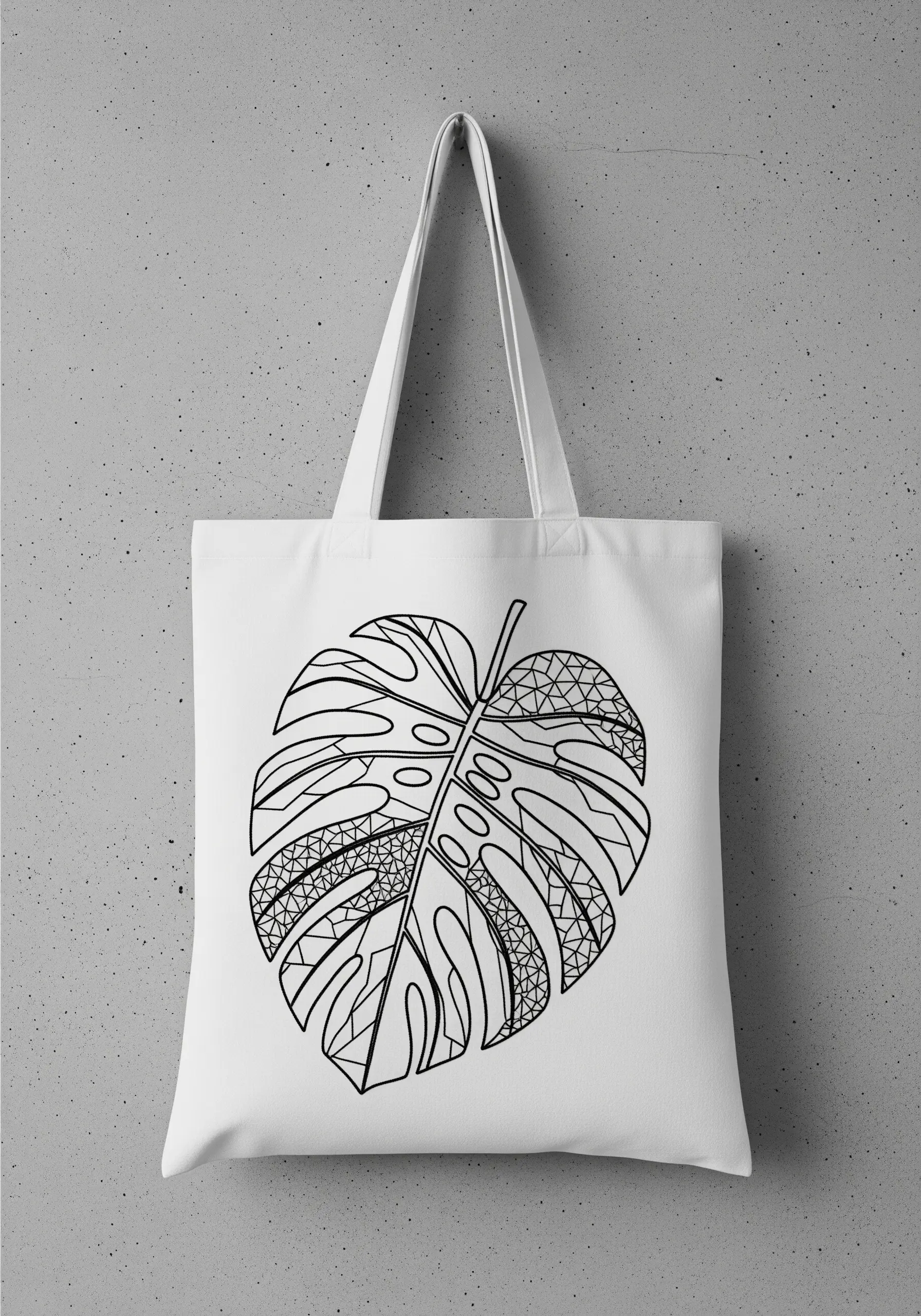 A large monstera leaf on a tote bag filled with various black and white geometric patterns.
