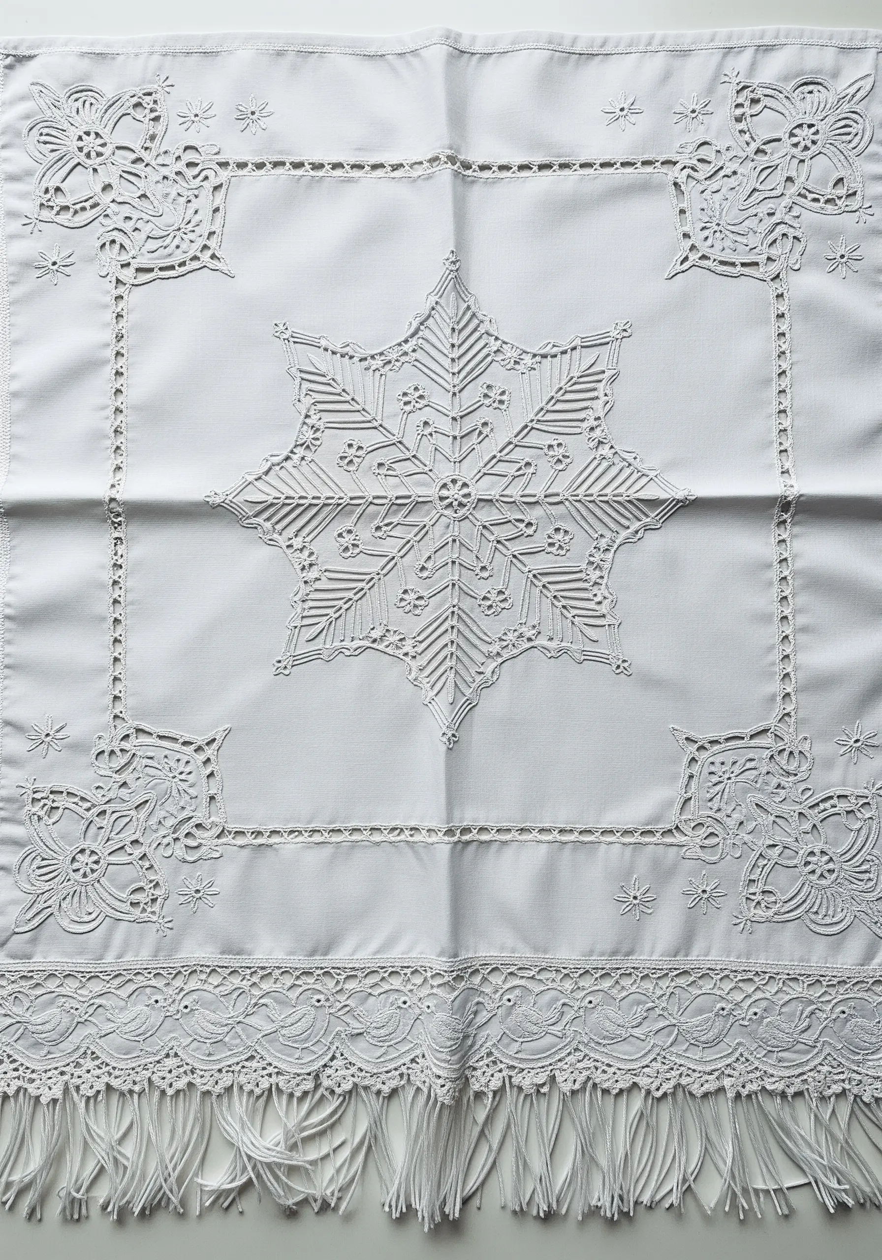 Geometric whitework embroidery featuring a central snowflake motif and drawn thread details.