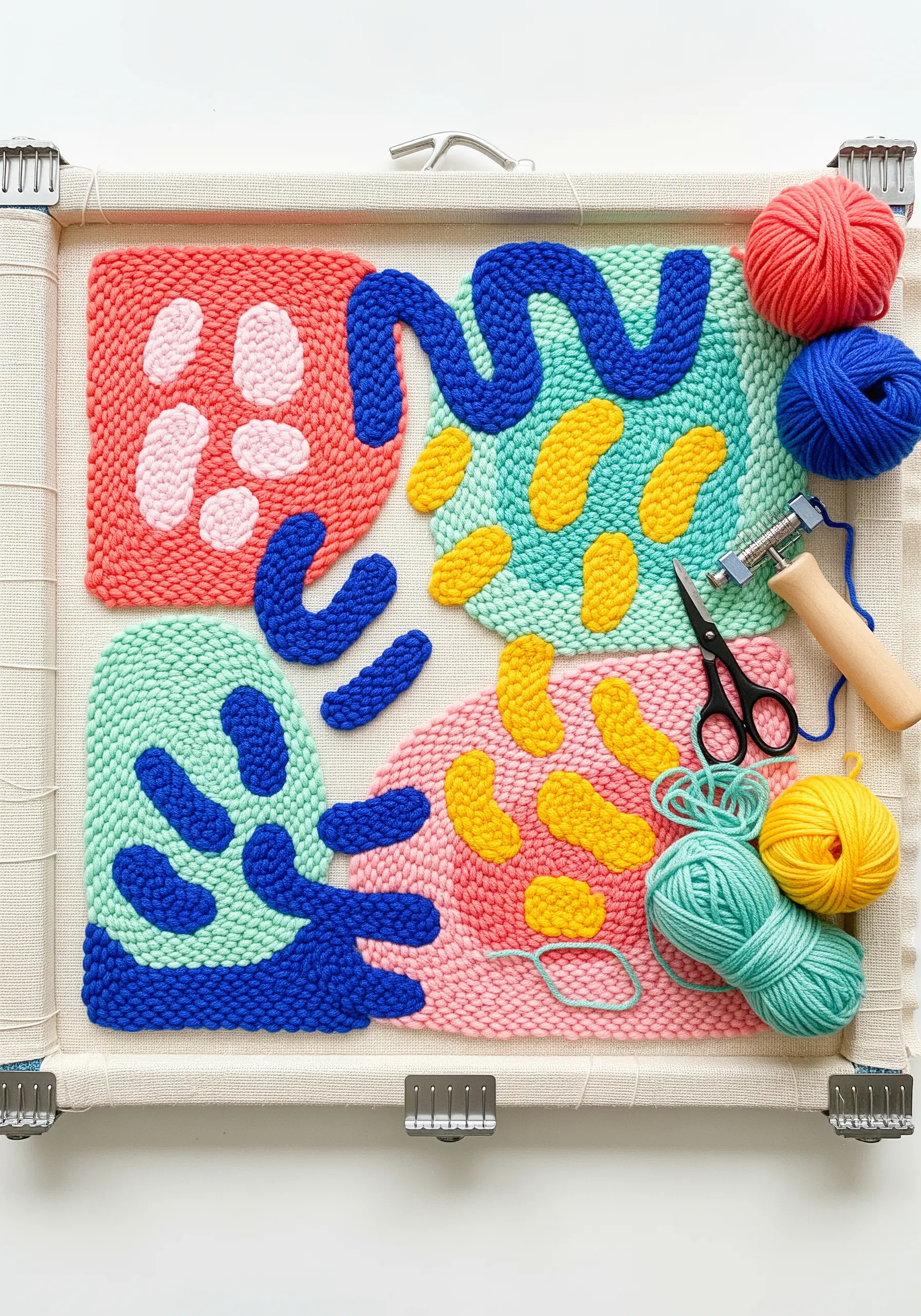 A vibrant abstract punch needle piece with colorful shapes and looped textures.