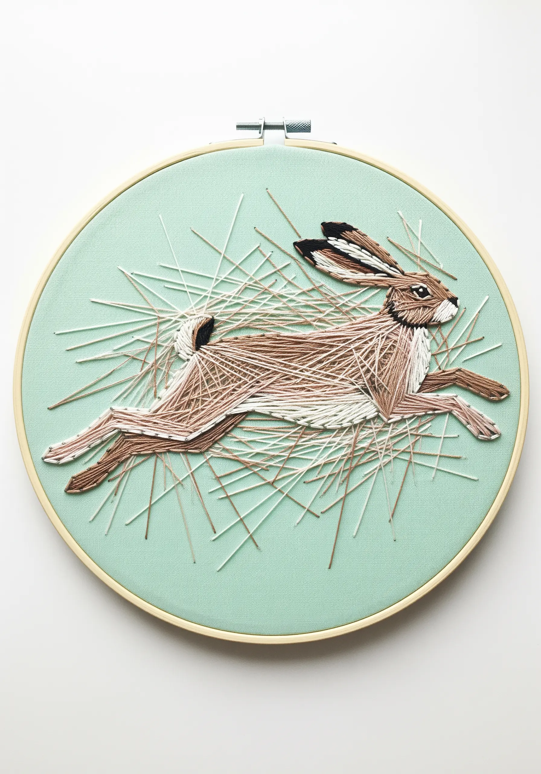 Embroidered running hare surrounded by abstract, chaotic stitches suggesting speed and grass.