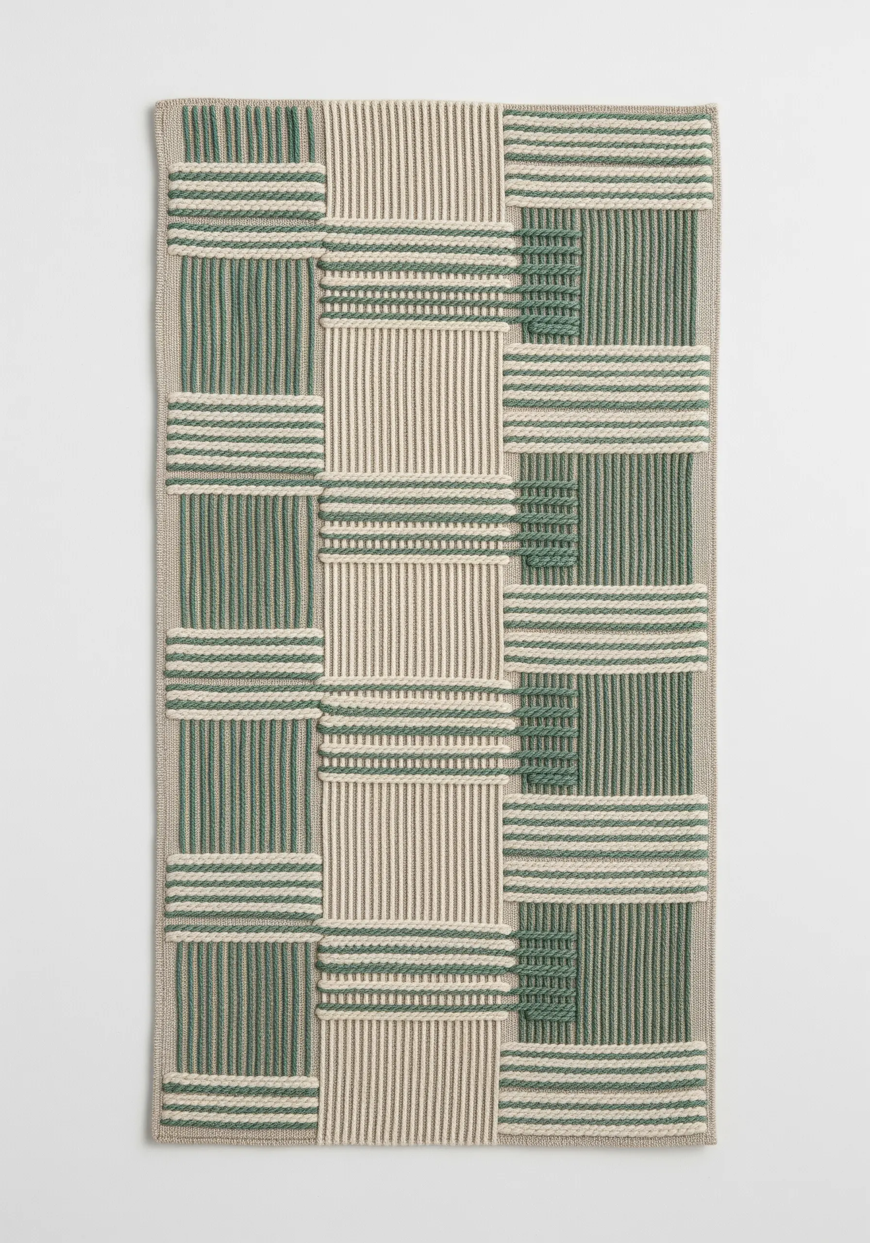 An abstract pattern that mimics woven fabric, using green and cream embroidery thread.