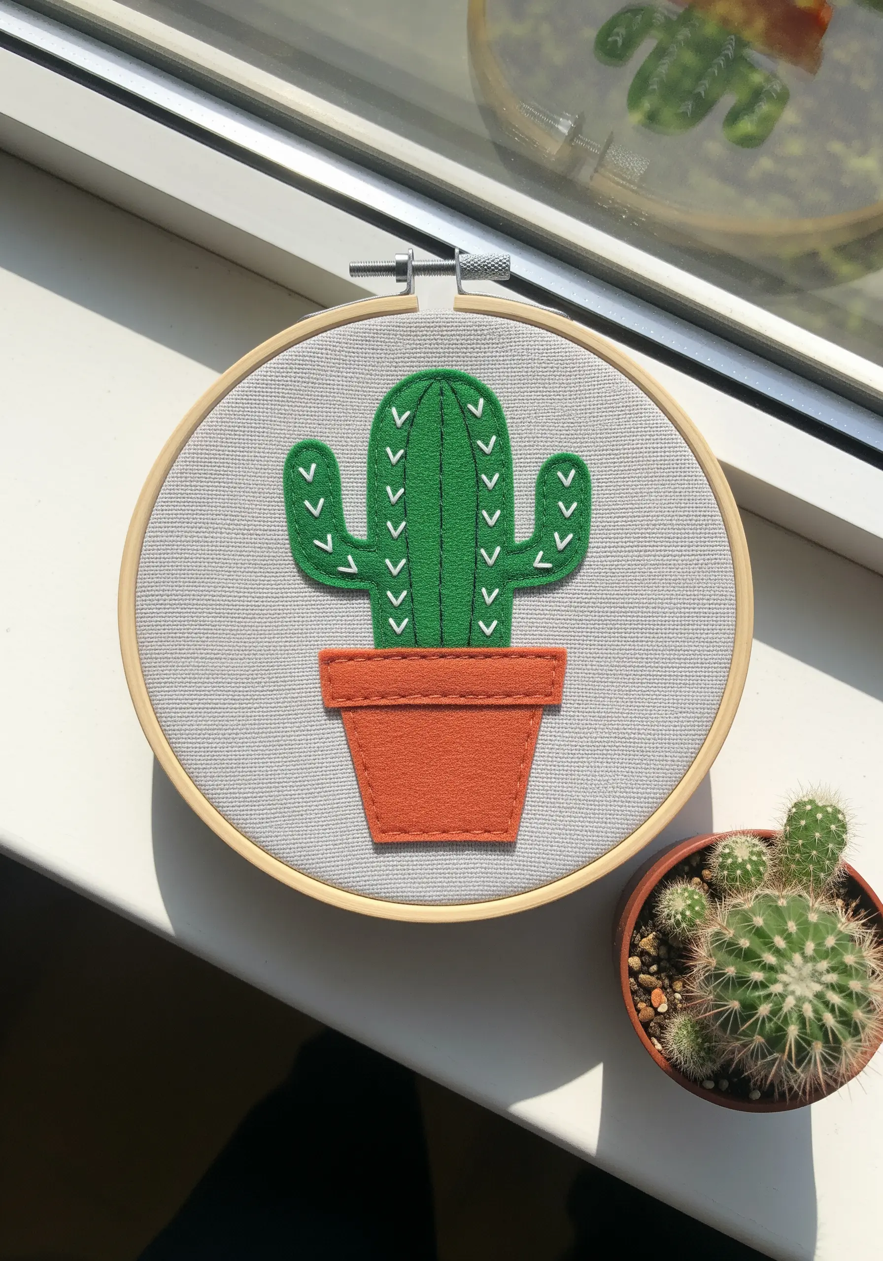 A green felt cactus appliqué with white V-stitches for spines.