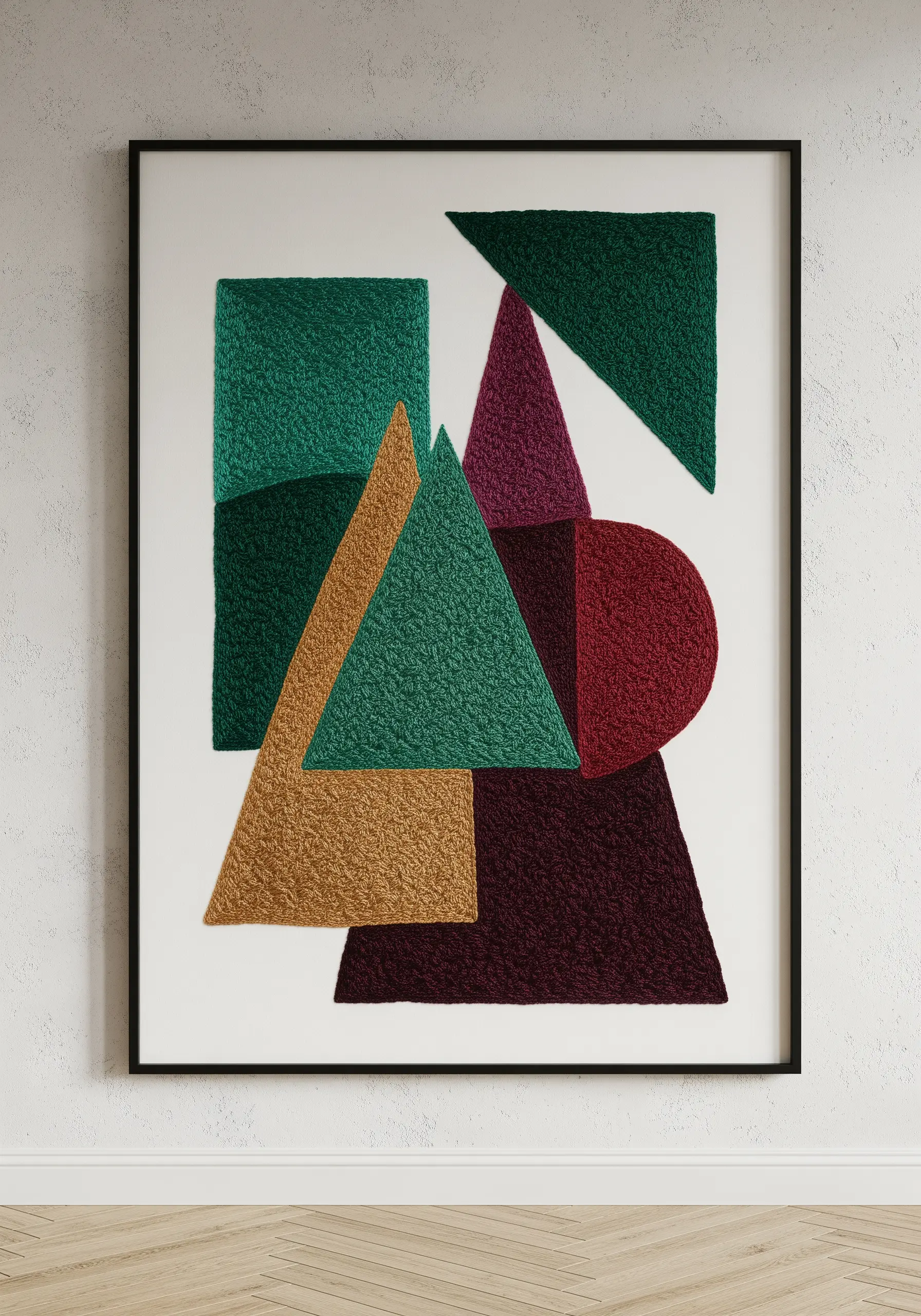 Framed abstract art with geometric shapes filled in with dense, textured embroidery stitches.