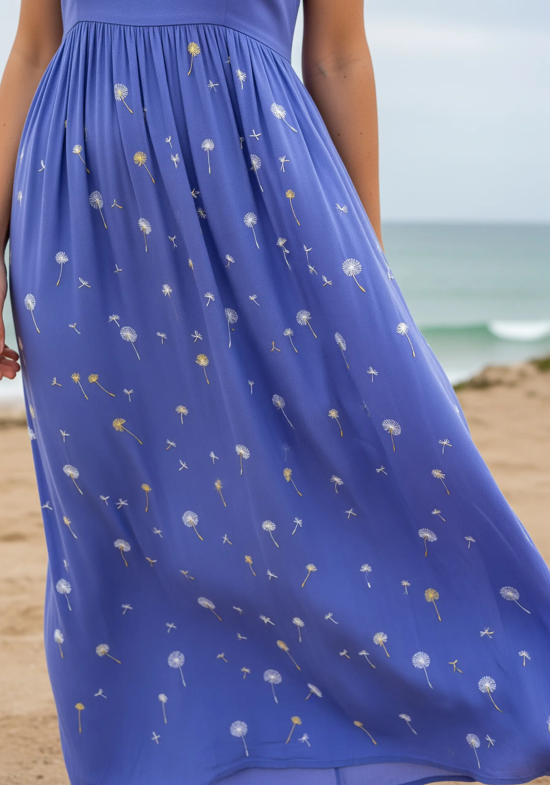 White and gold dandelion seeds embroidered as if floating down a periwinkle blue maxi dress.