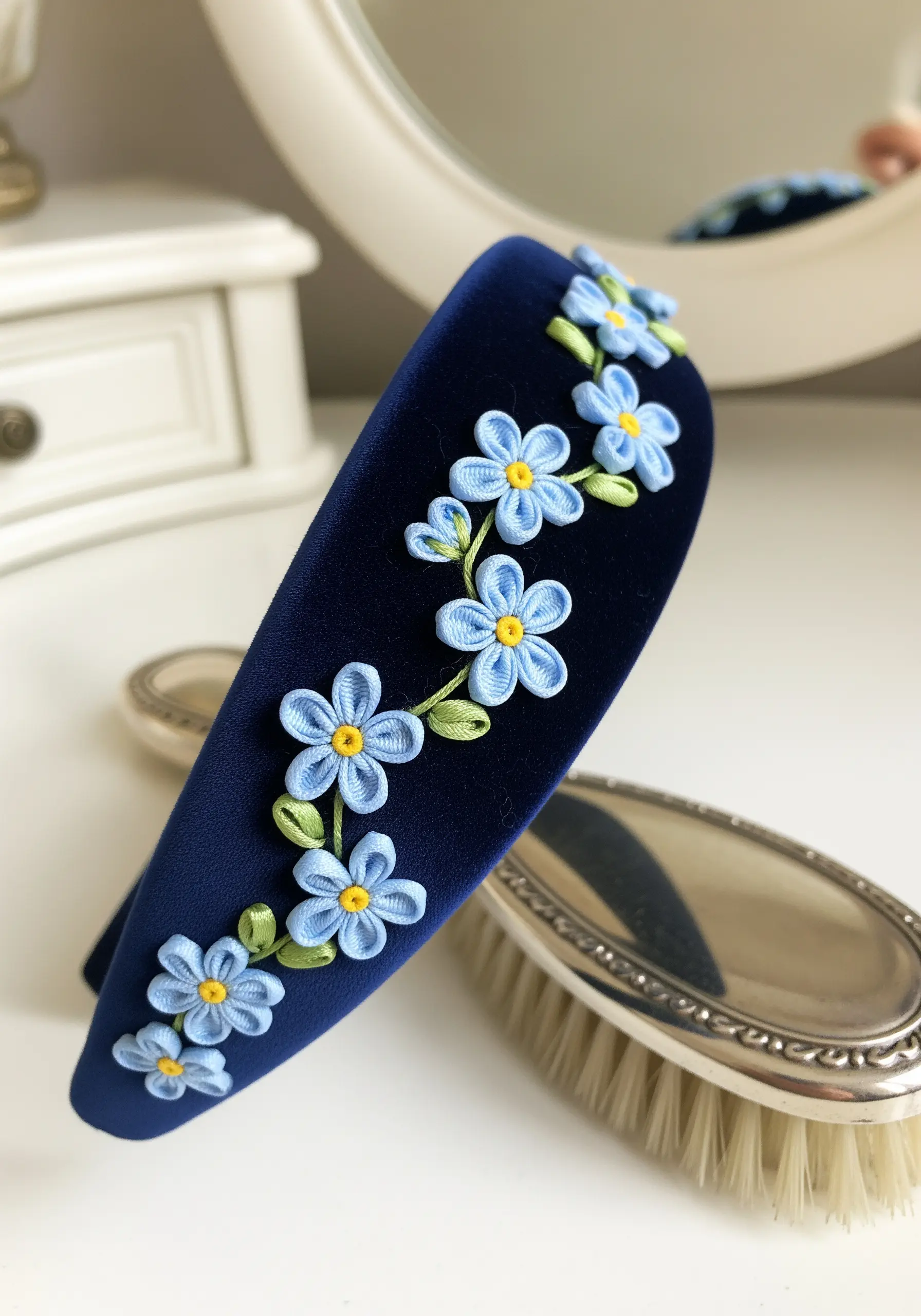 Delicate blue forget-me-nots made with ribbon embroidery trailing along a navy velvet headband.