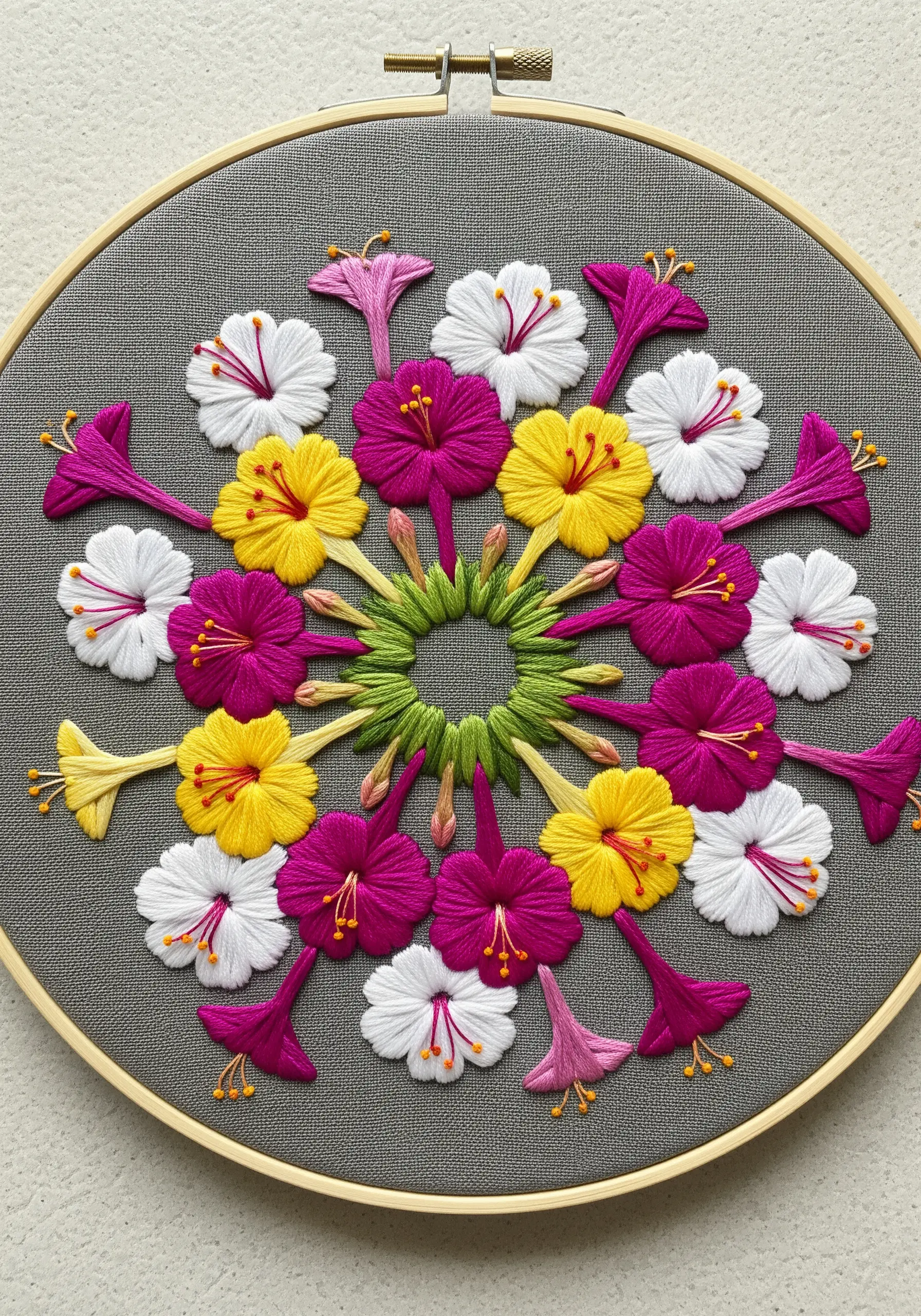 A colorful mandala of pink, yellow, and white Four O'Clock flowers on grey fabric.