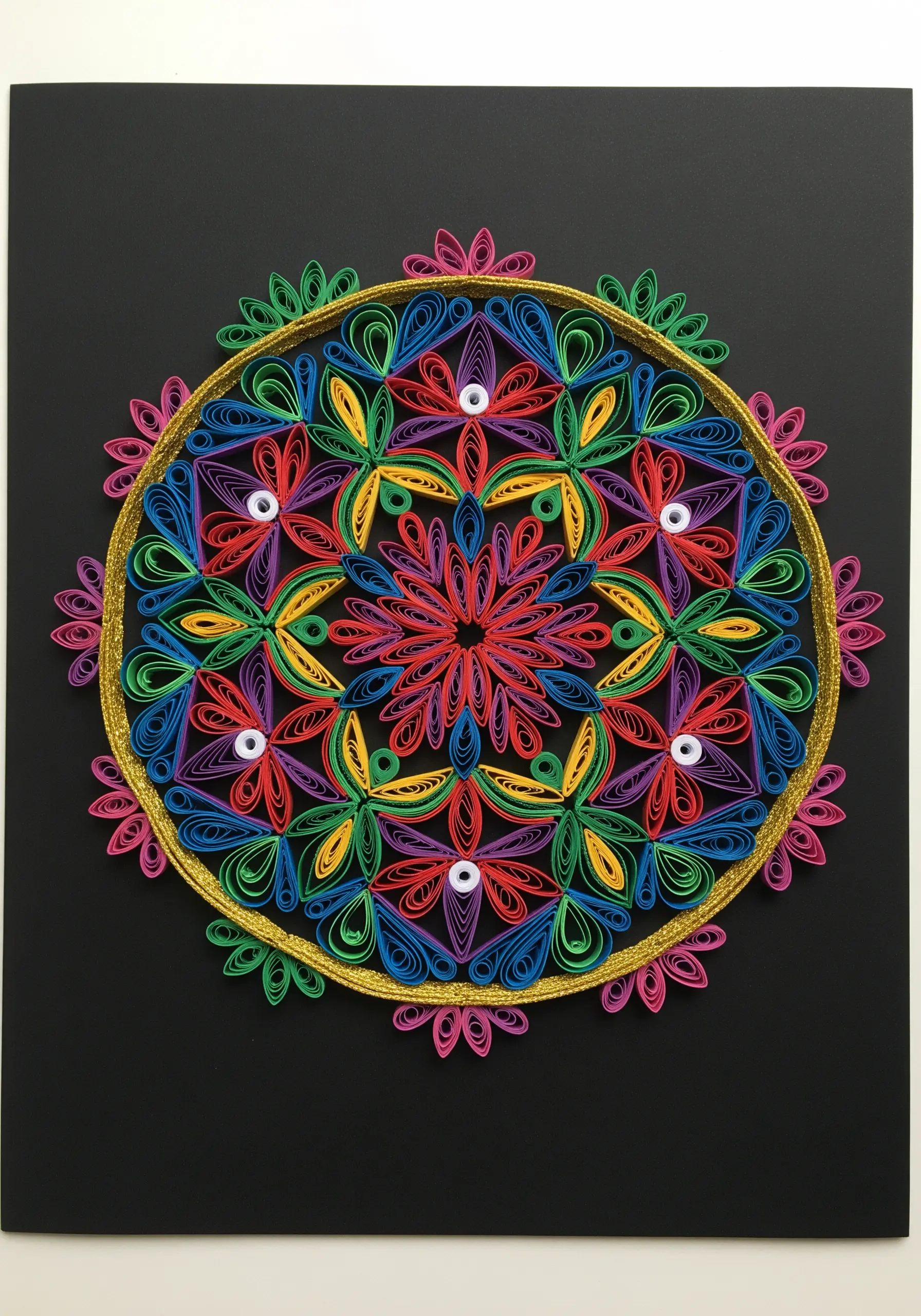 A vibrant paper quilled mandala outlined with a couched gold metallic thread border.