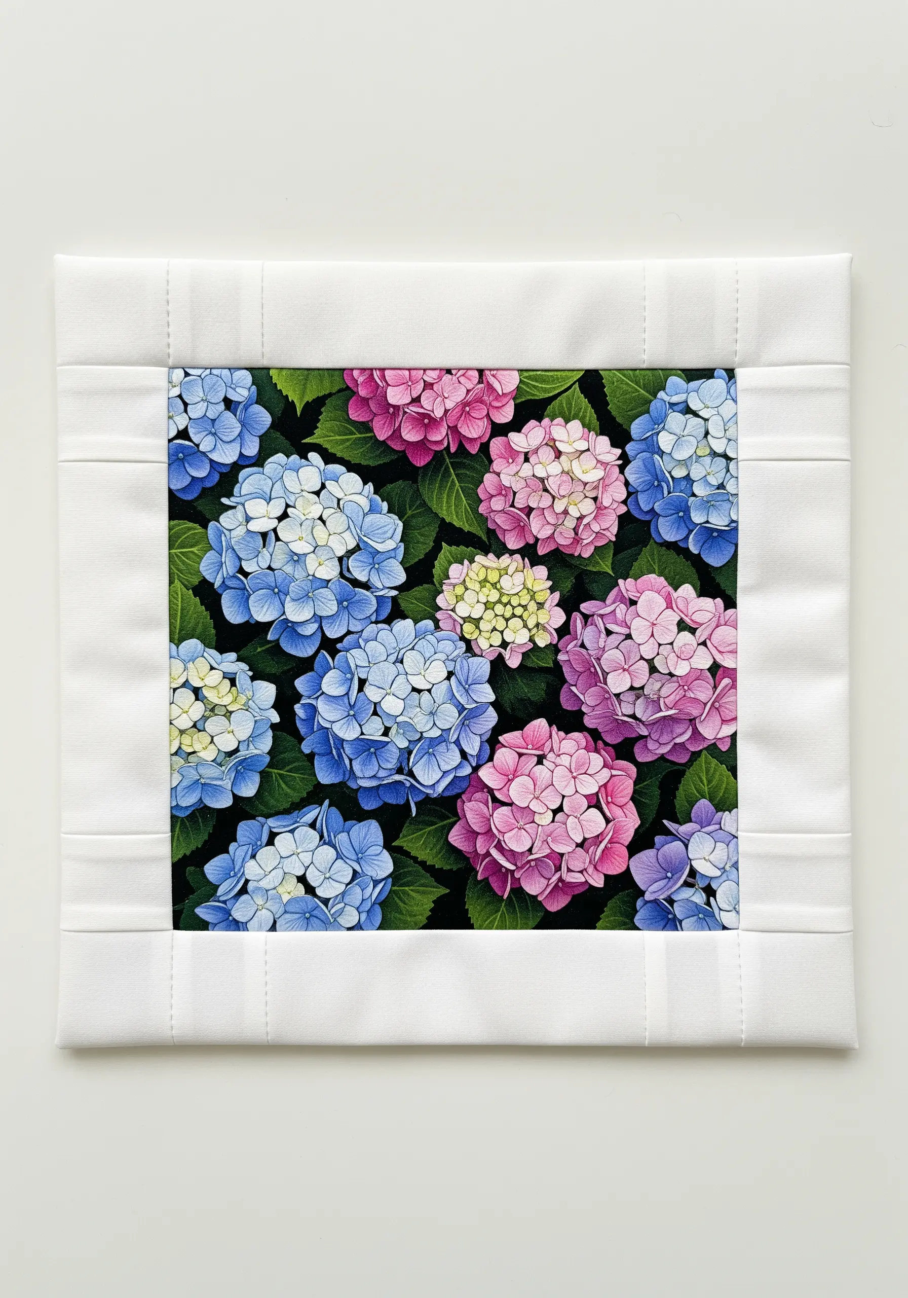 A detailed, colorful hydrangea embroidery panel framed by a clean, white quilted border.