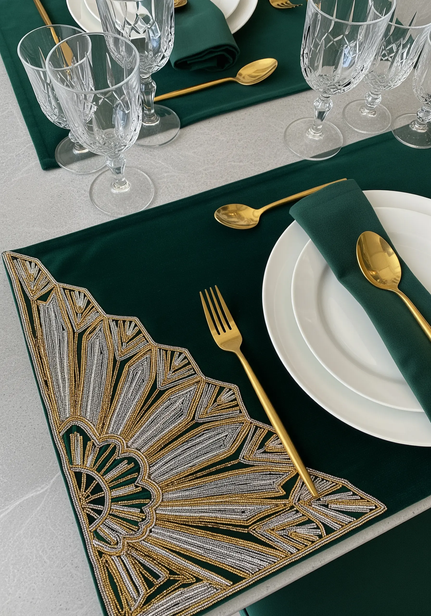 Art deco placemat with gold and silver metallic thread and bead embroidery in a fan shape.