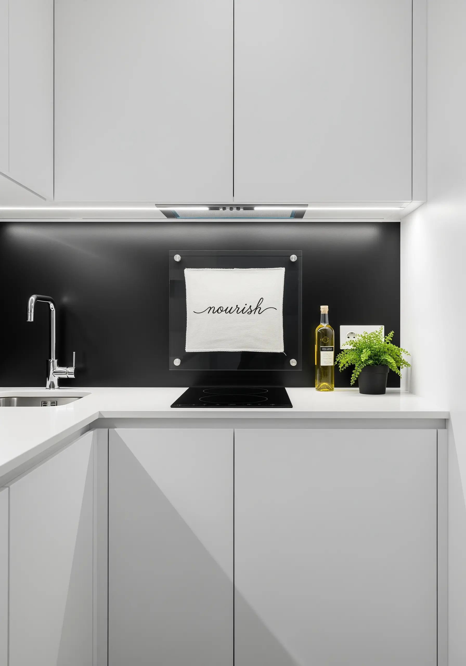 The word 'nourish' embroidered in delicate black script on a white cloth in a modern kitchen.