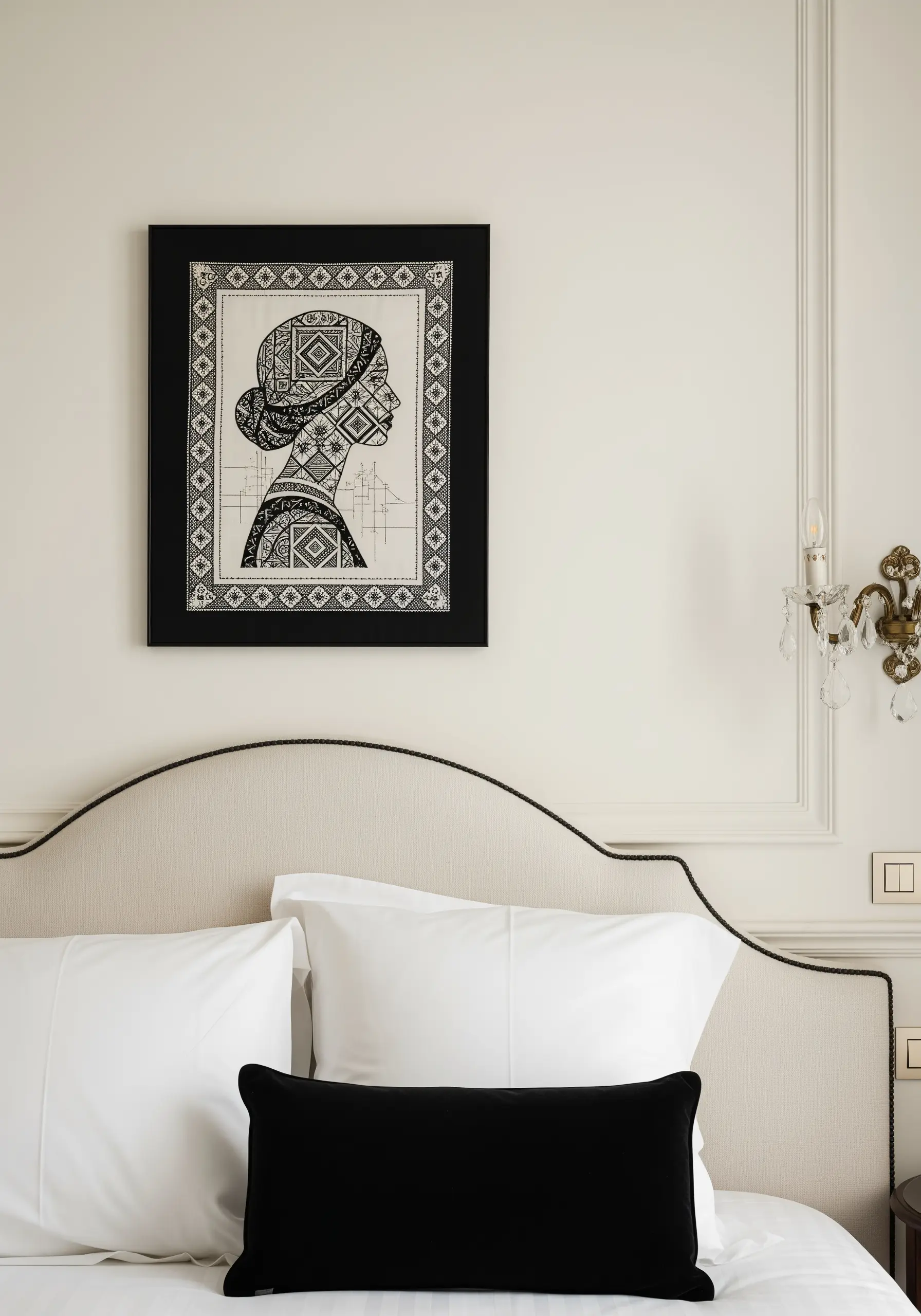 A framed blackwork embroidery depicting a woman's silhouette filled with geometric patterns.