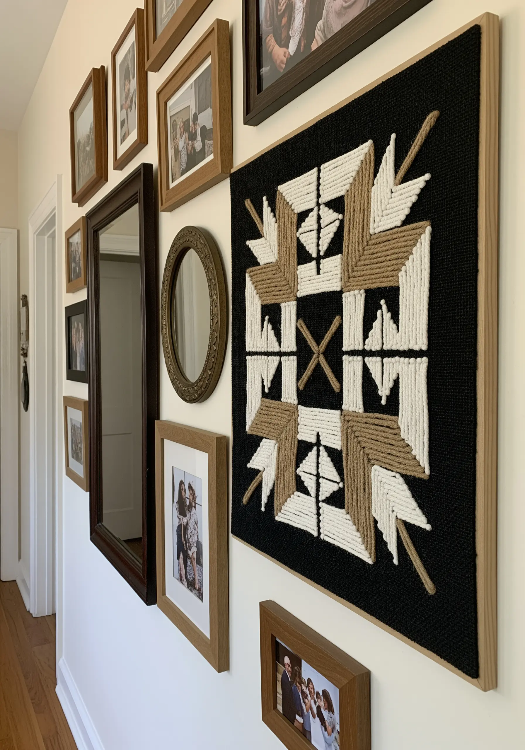 A large, framed geometric wall art piece made with couched white and jute-colored yarn.