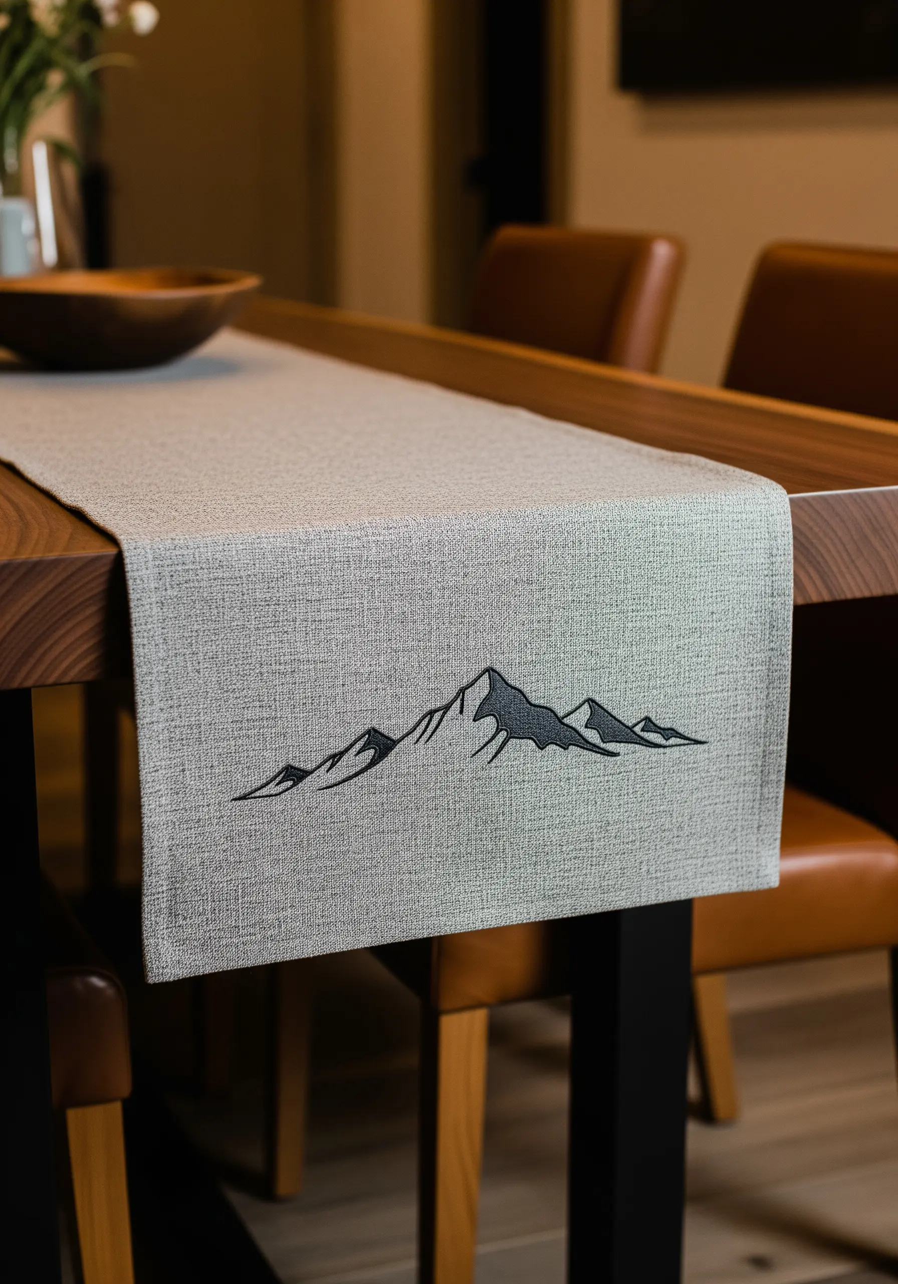 A minimalist mountain range embroidered with black and gray satin stitch