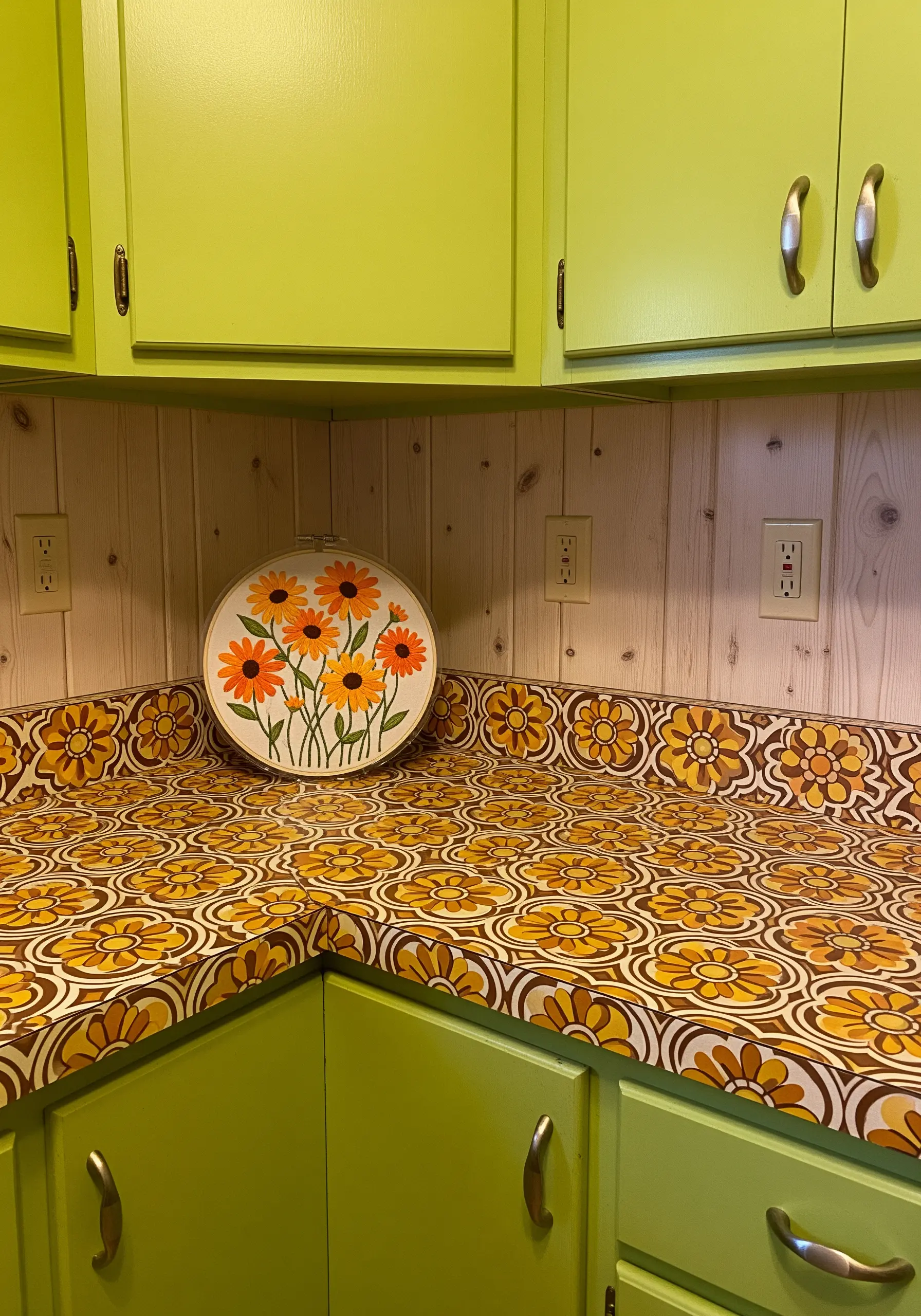 Retro floral embroidery hoop in orange and yellow, matching the countertop in a vintage kitchen.