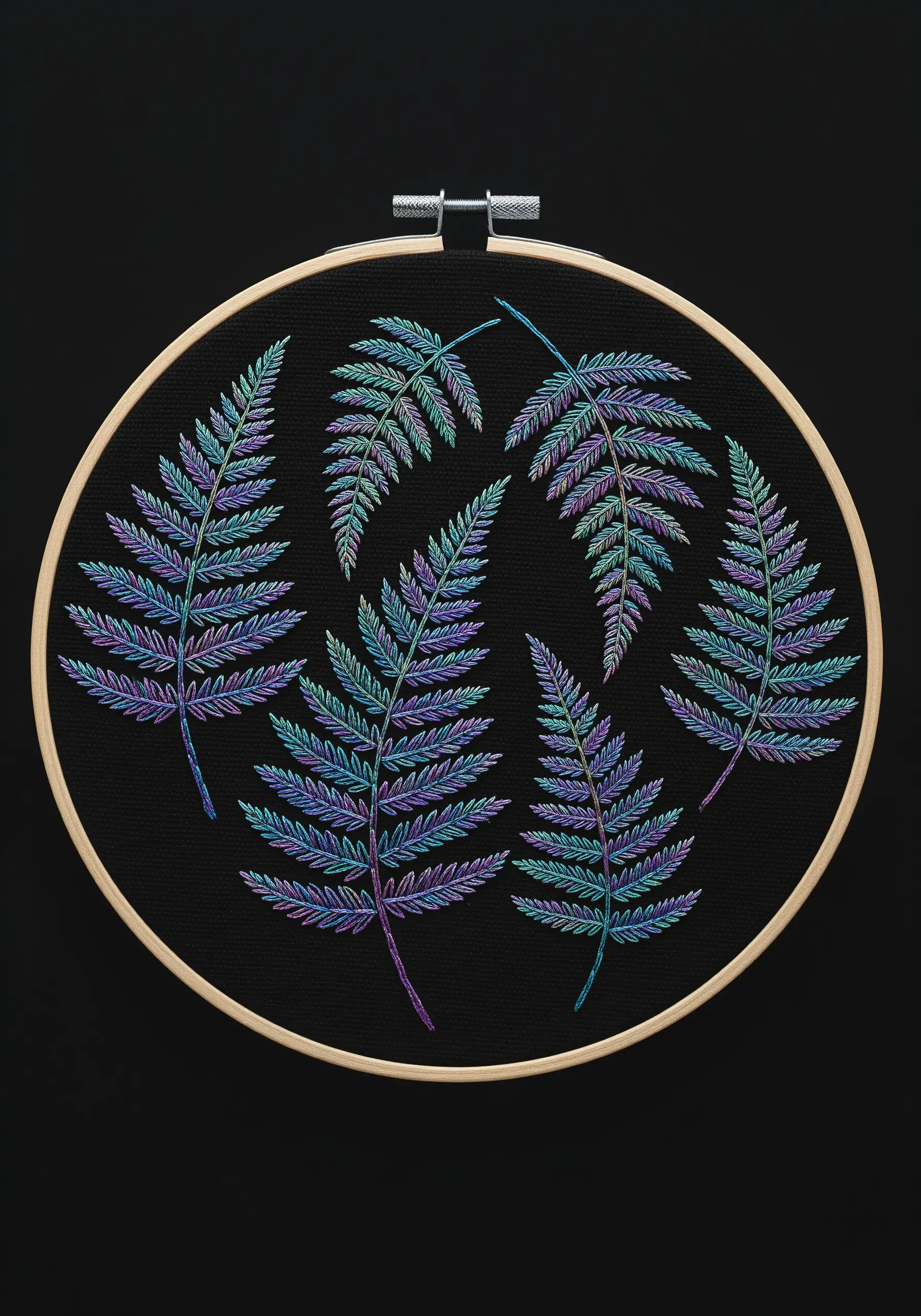 Several fern leaves embroidered on black fabric using a variegated thread of blue, purple, and green.