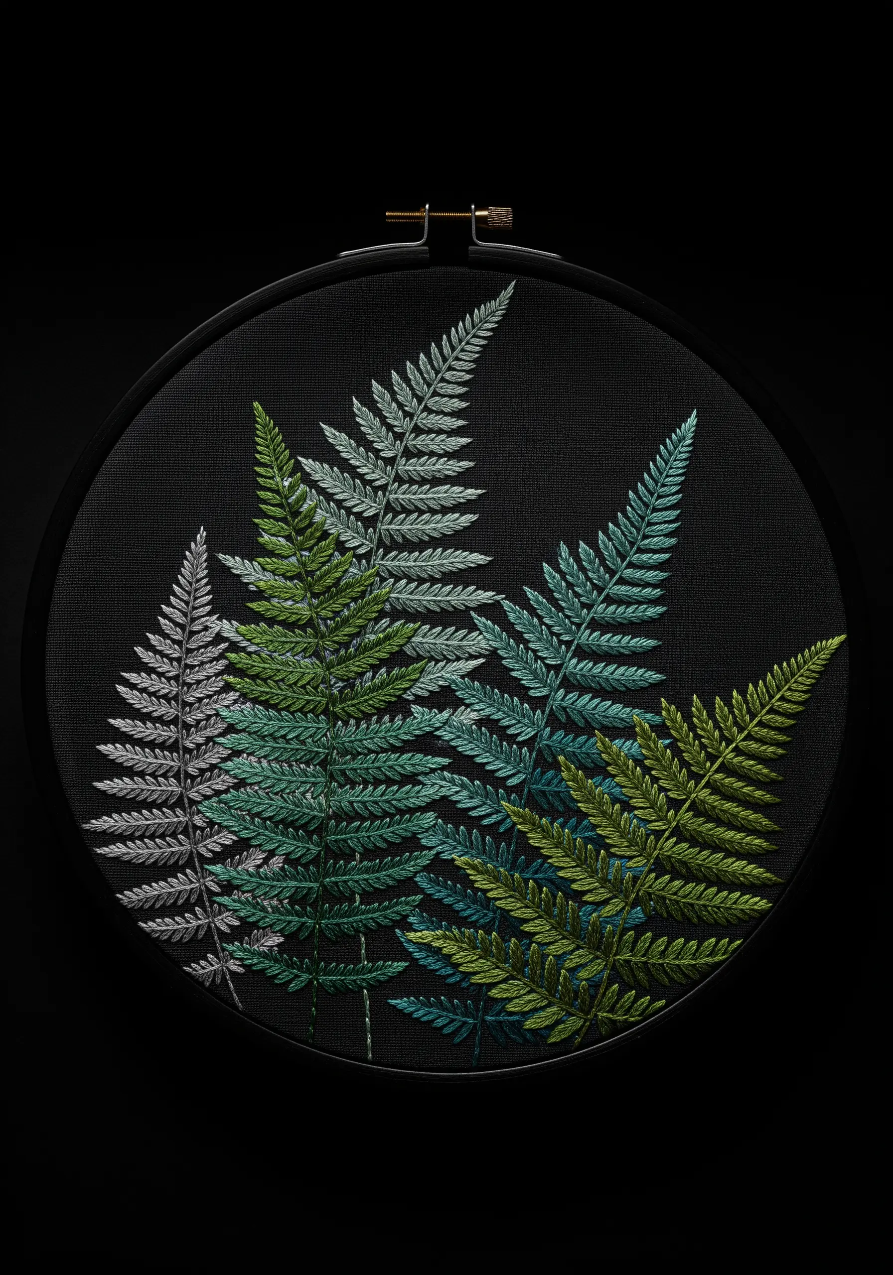 Four fern fronds in shades of green and silver stitched on a stark black fabric background.