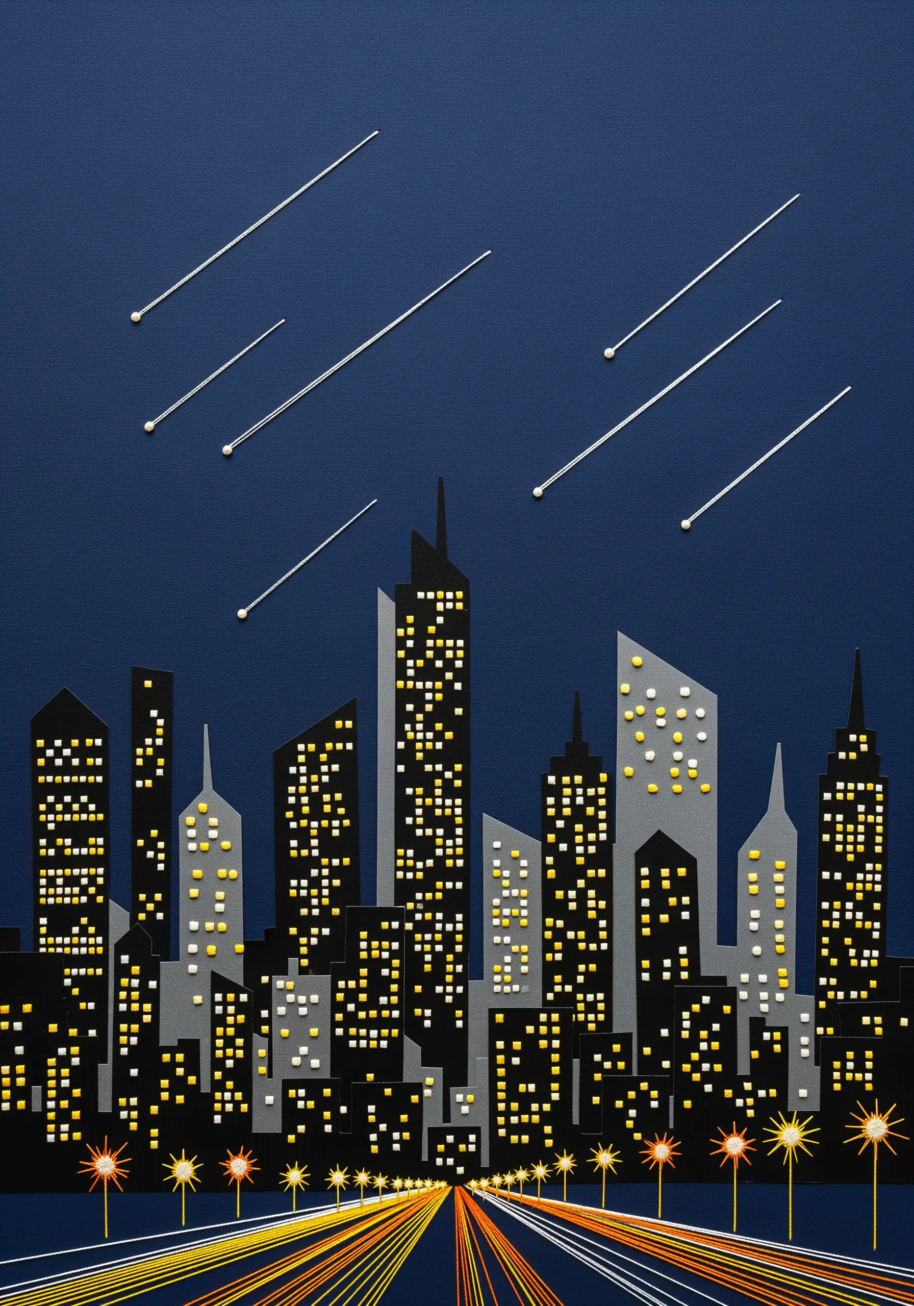 A paper collage cityscape with embroidered French knot lights and straight-stitch shooting stars.