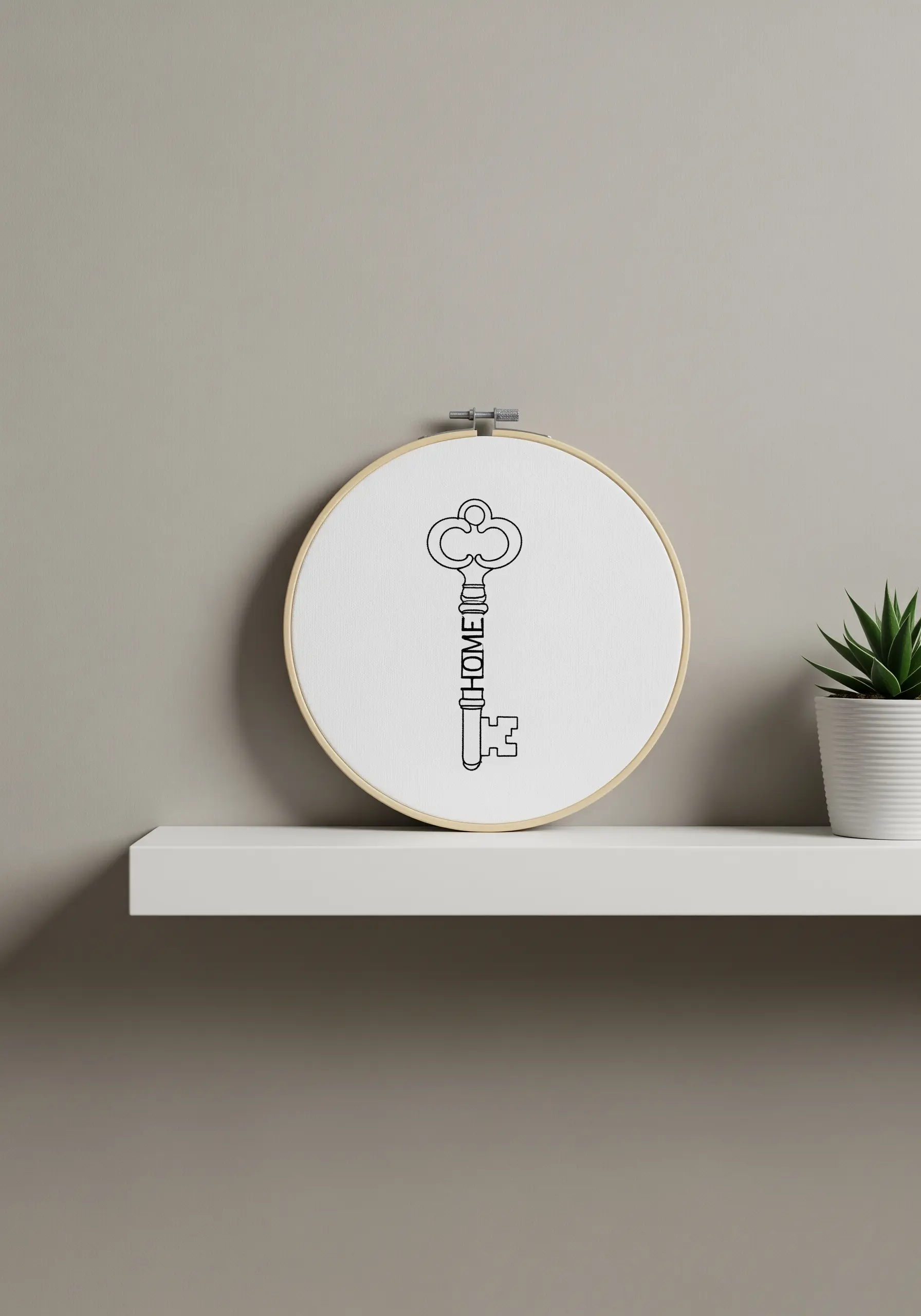 A simple line art embroidery of a key with the word 'HOME' integrated into the design.