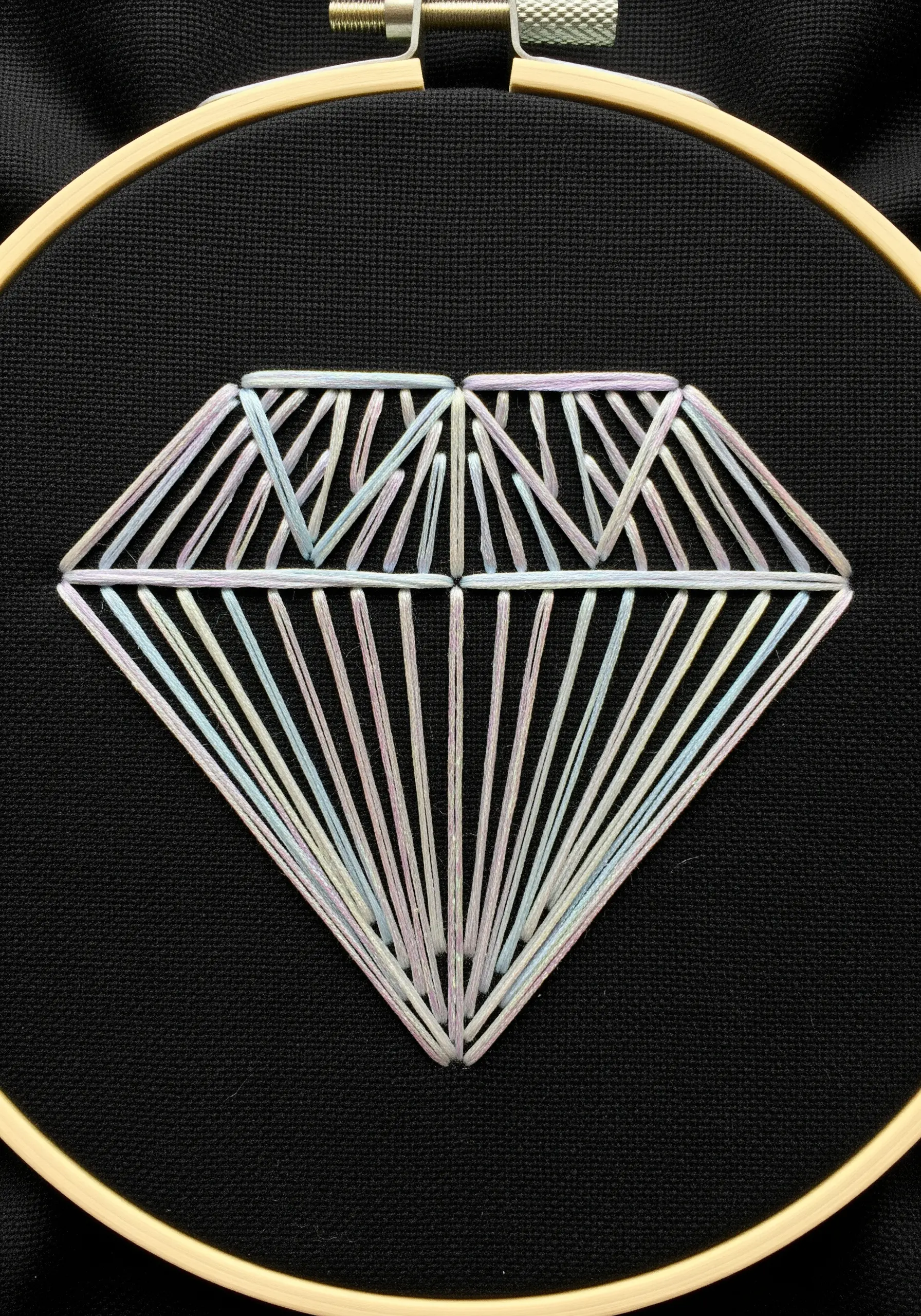 Geometric diamond embroidered with iridescent straight stitches on black fabric.