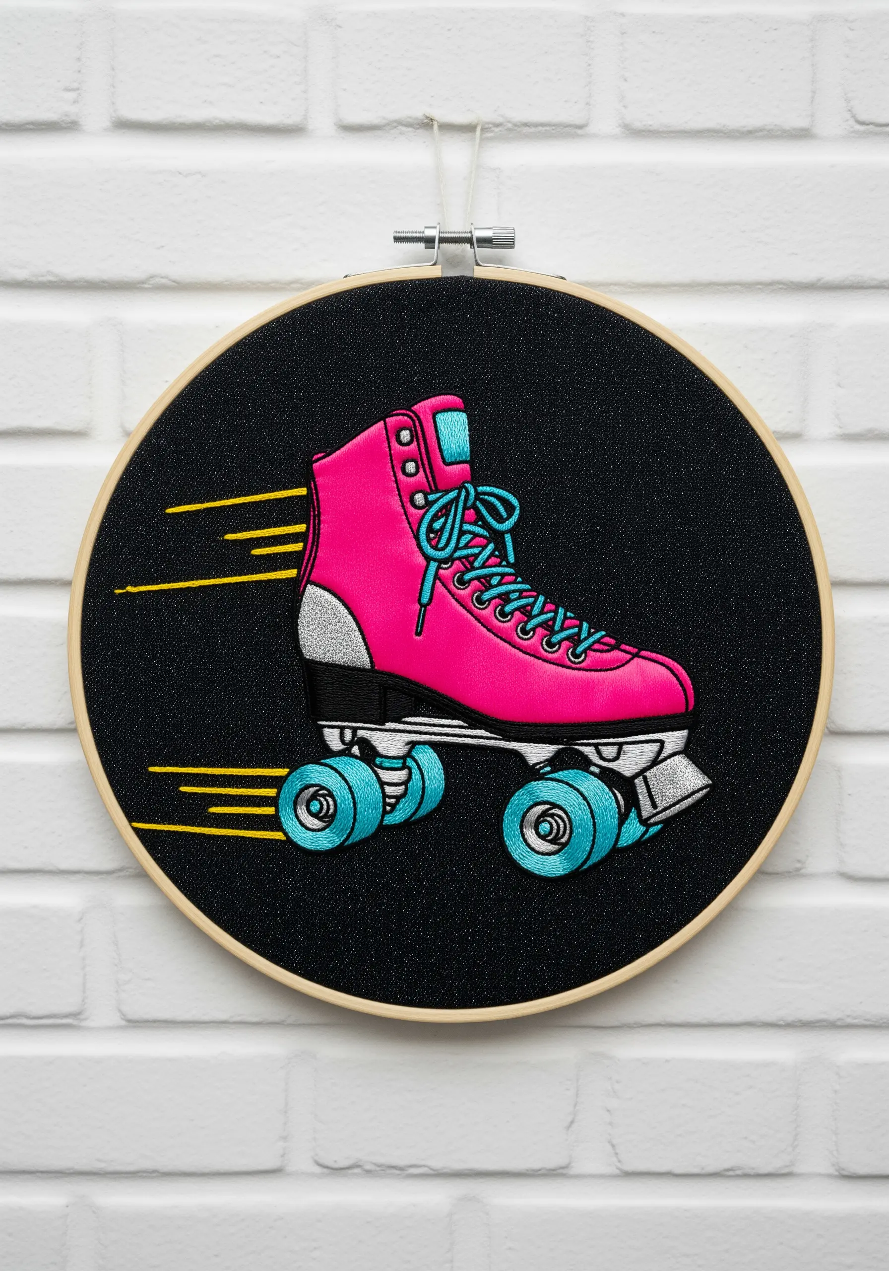 Retro roller skate embroidery on black fabric with dynamic satin stitches.