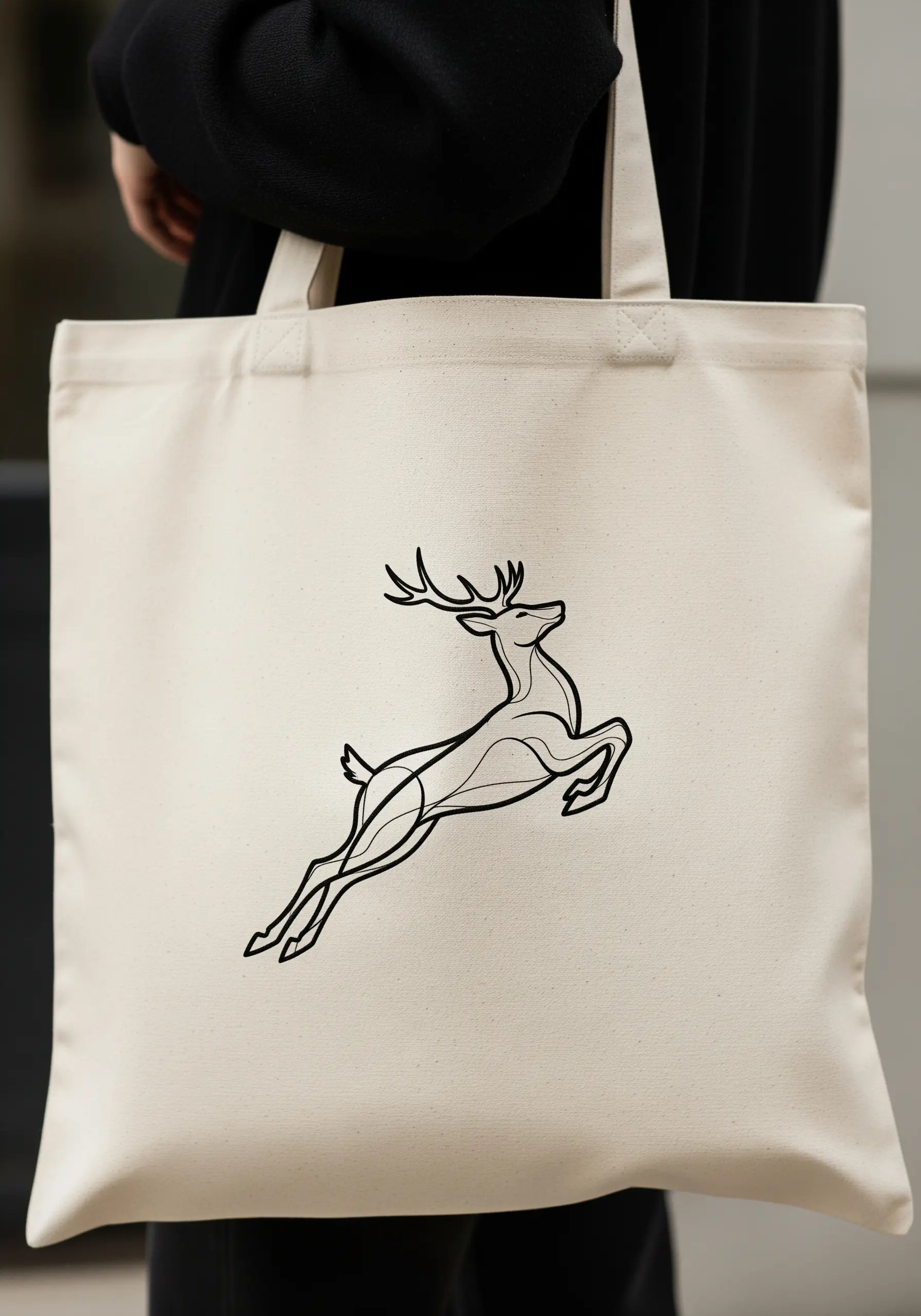 Line art embroidery of a leaping deer on a canvas tote bag.