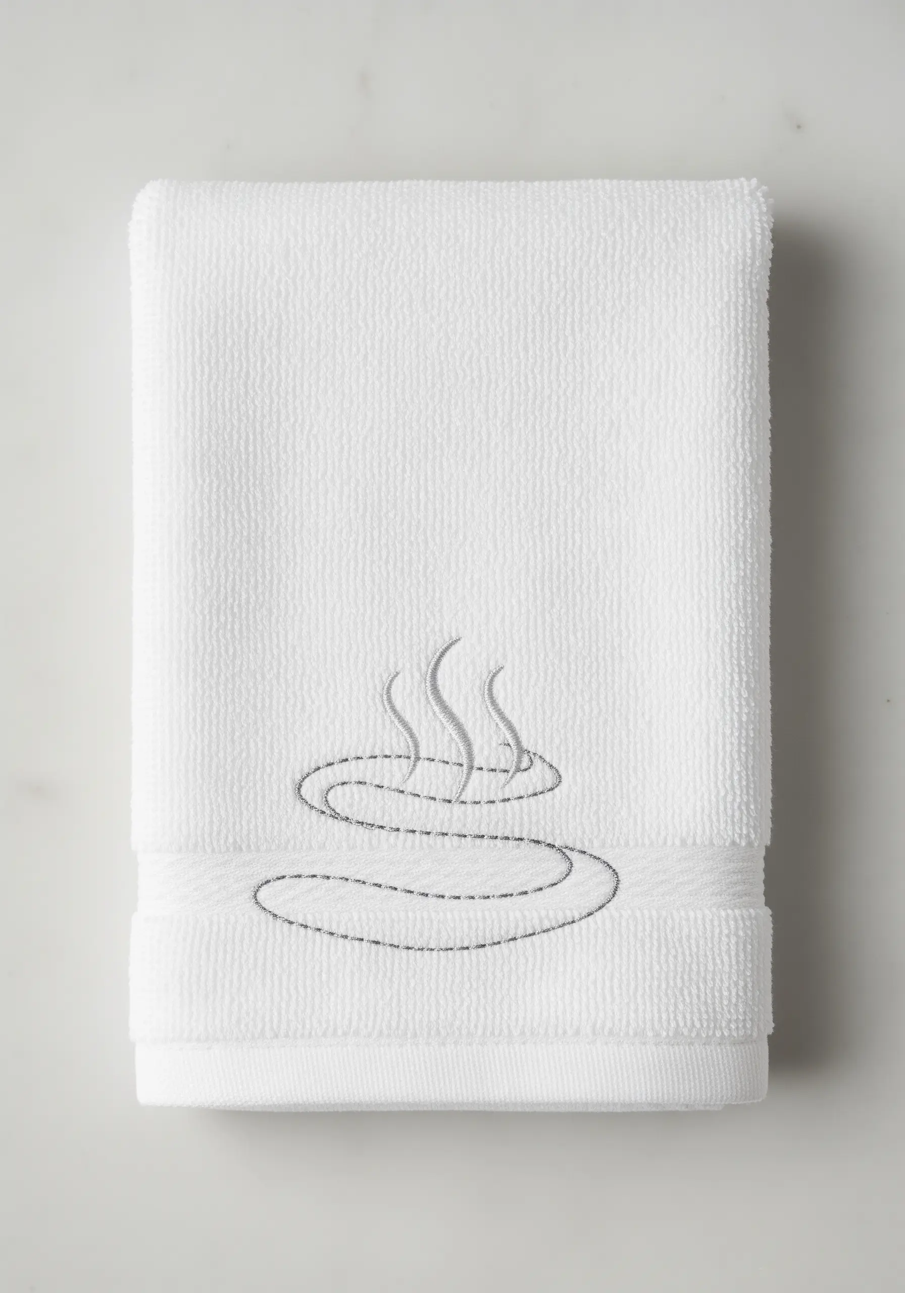 A minimalist embroidery of steam rising from a hot spring on a folded white towel.