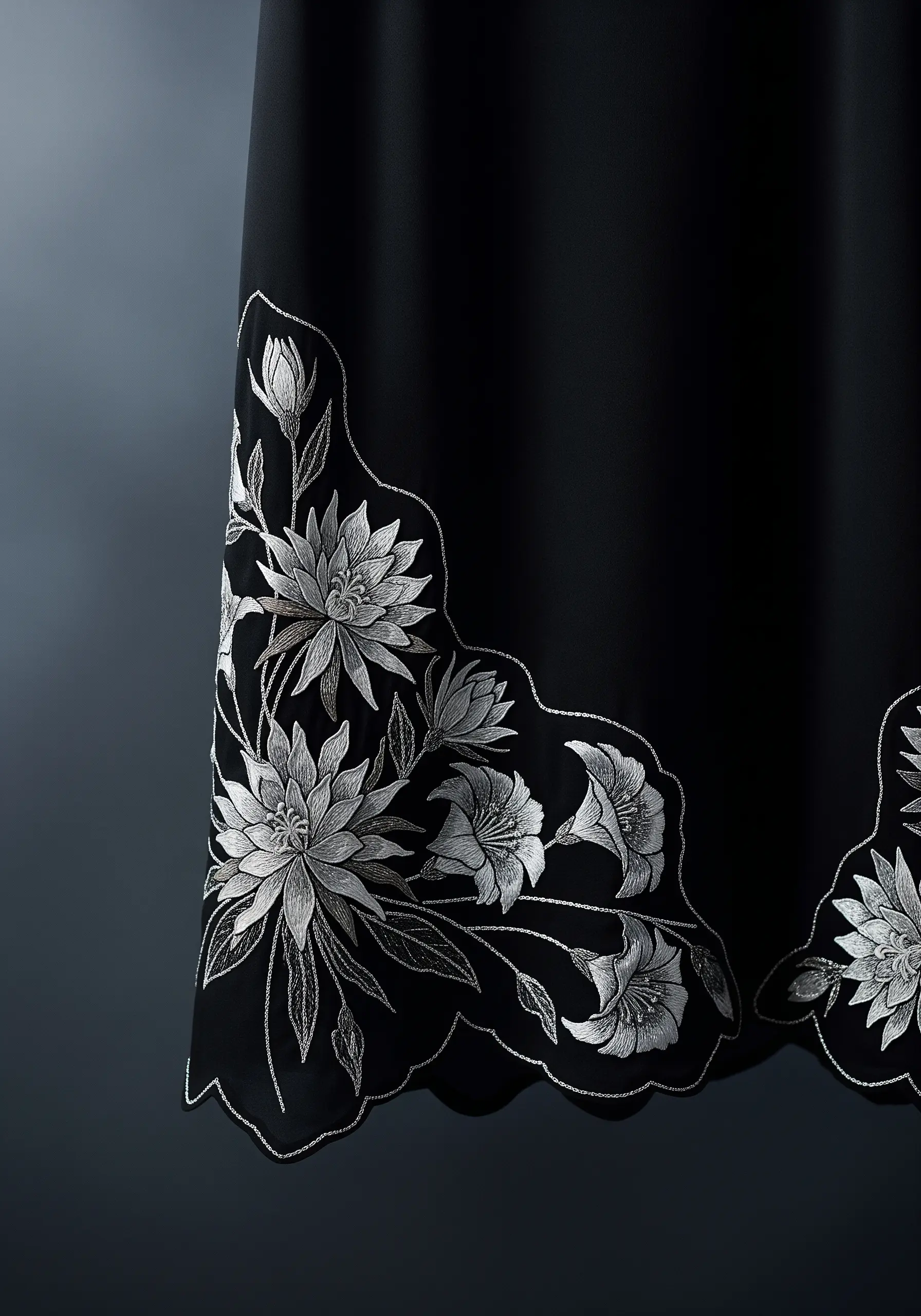 Intricate white floral embroidery creating a scalloped edge on a black skirt