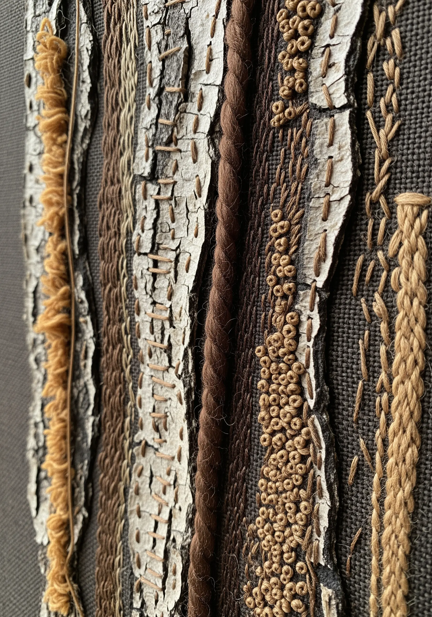 A mixed-media embroidery piece featuring real tree bark stitched over with textured threads.