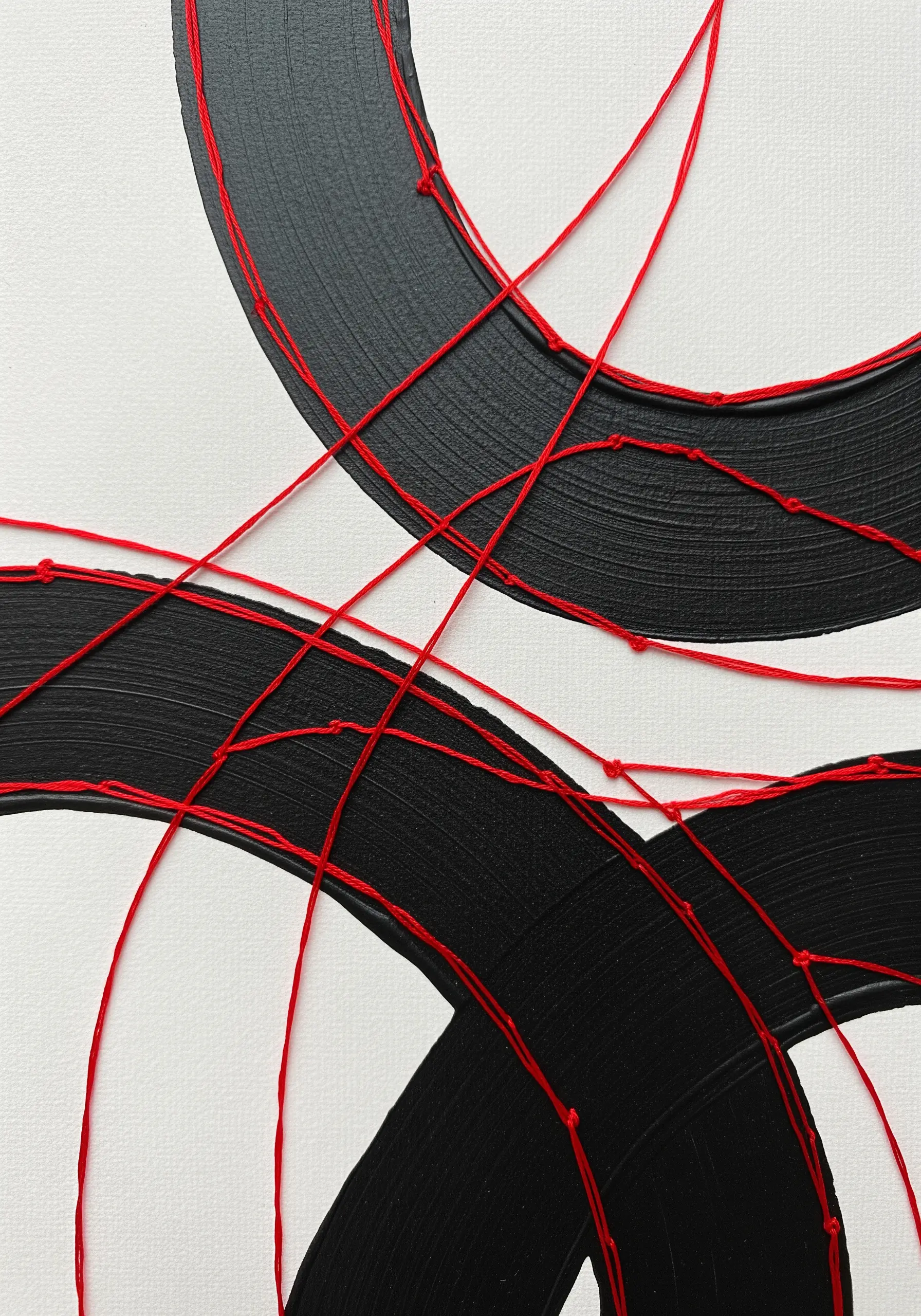 Red thread stitched over bold black paint strokes on a white canvas.