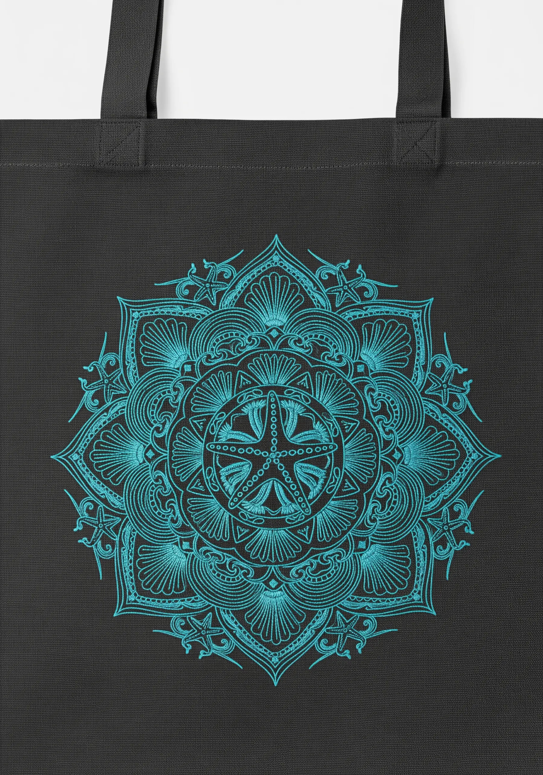 A highly intricate, symmetrical mandala in turquoise thread on a black canvas tote bag.
